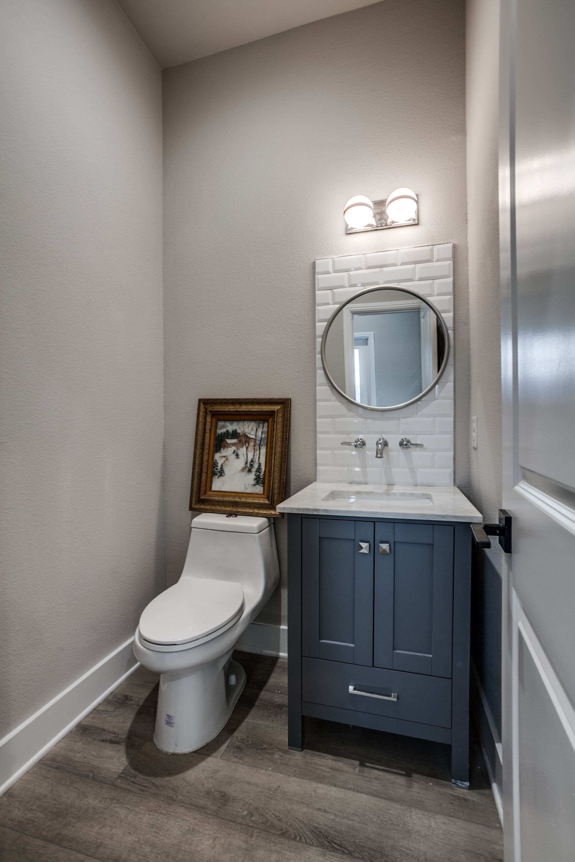 A bathroom with a toilet , sink and mirror.