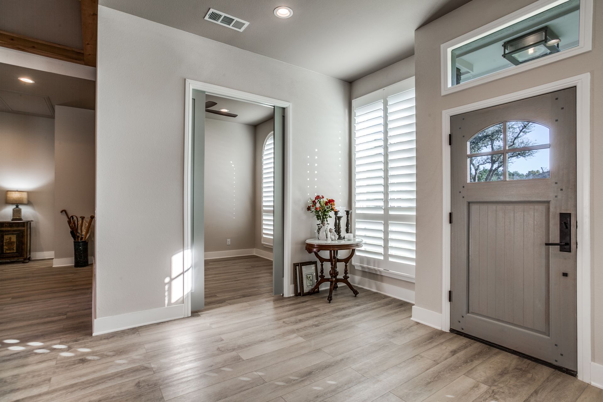 A hallway with a table and a door in a house.