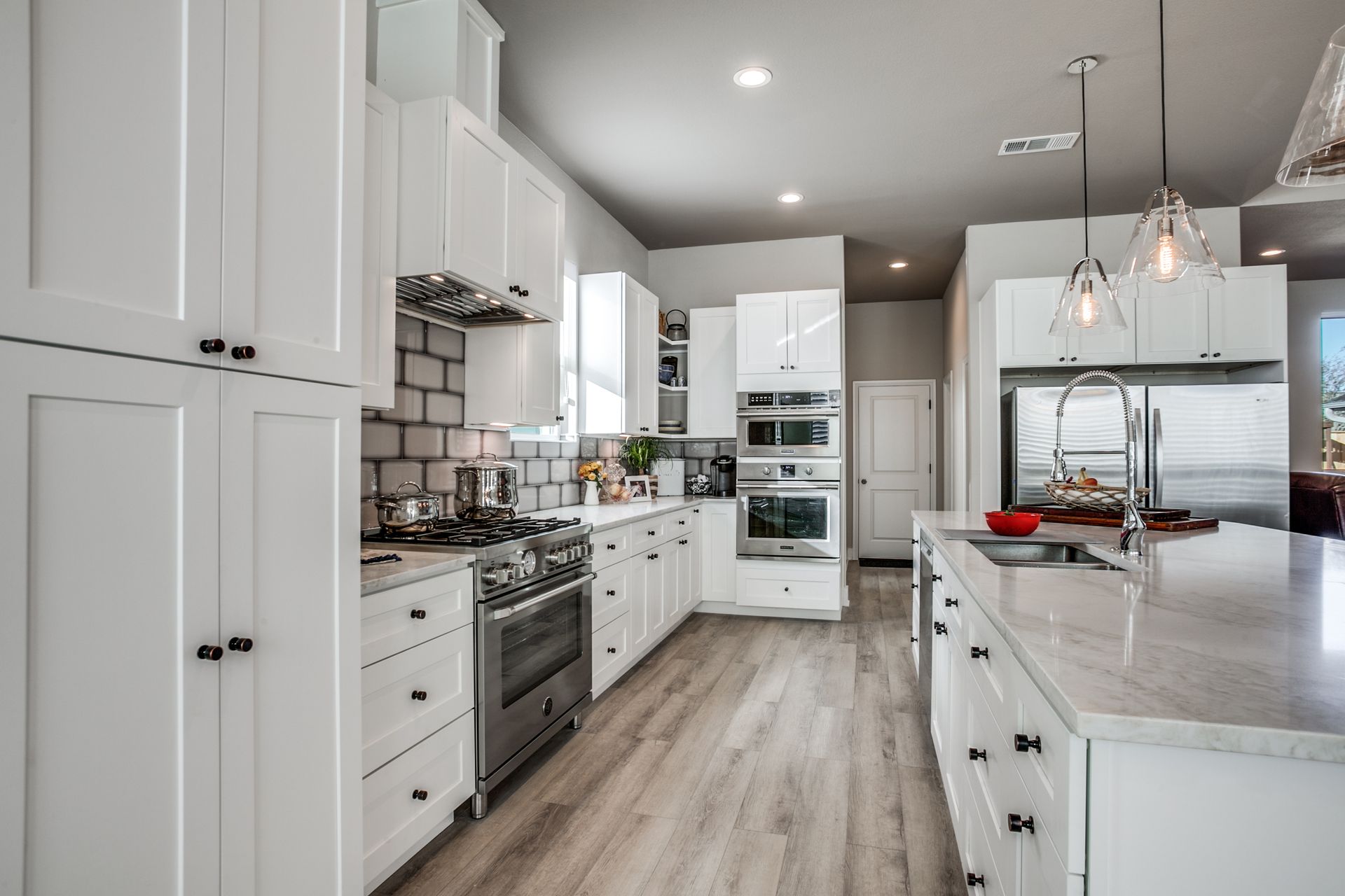 A kitchen with white cabinets and stainless steel appliances