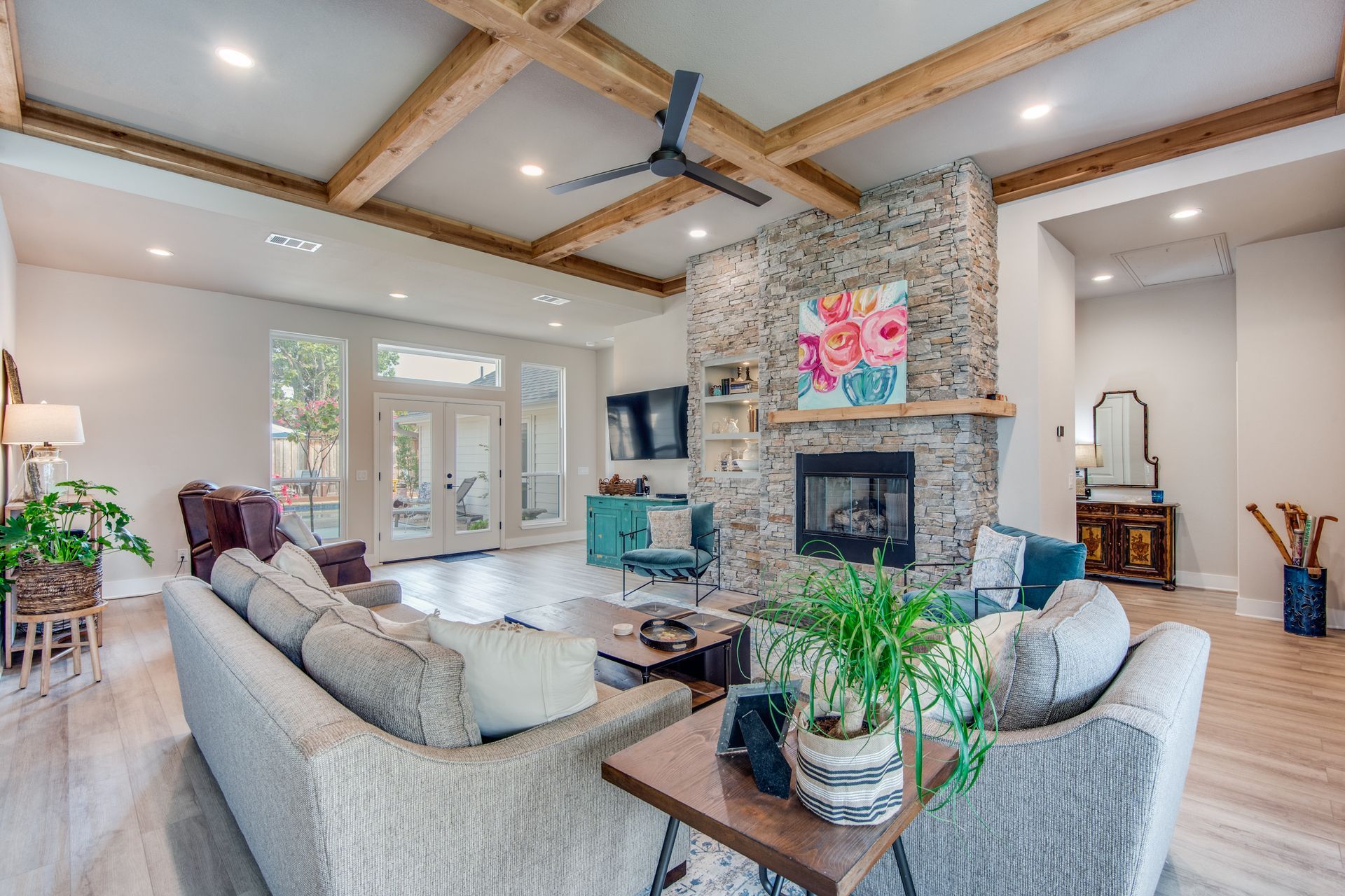 A living room with a couch , chairs , a fireplace and a ceiling fan.