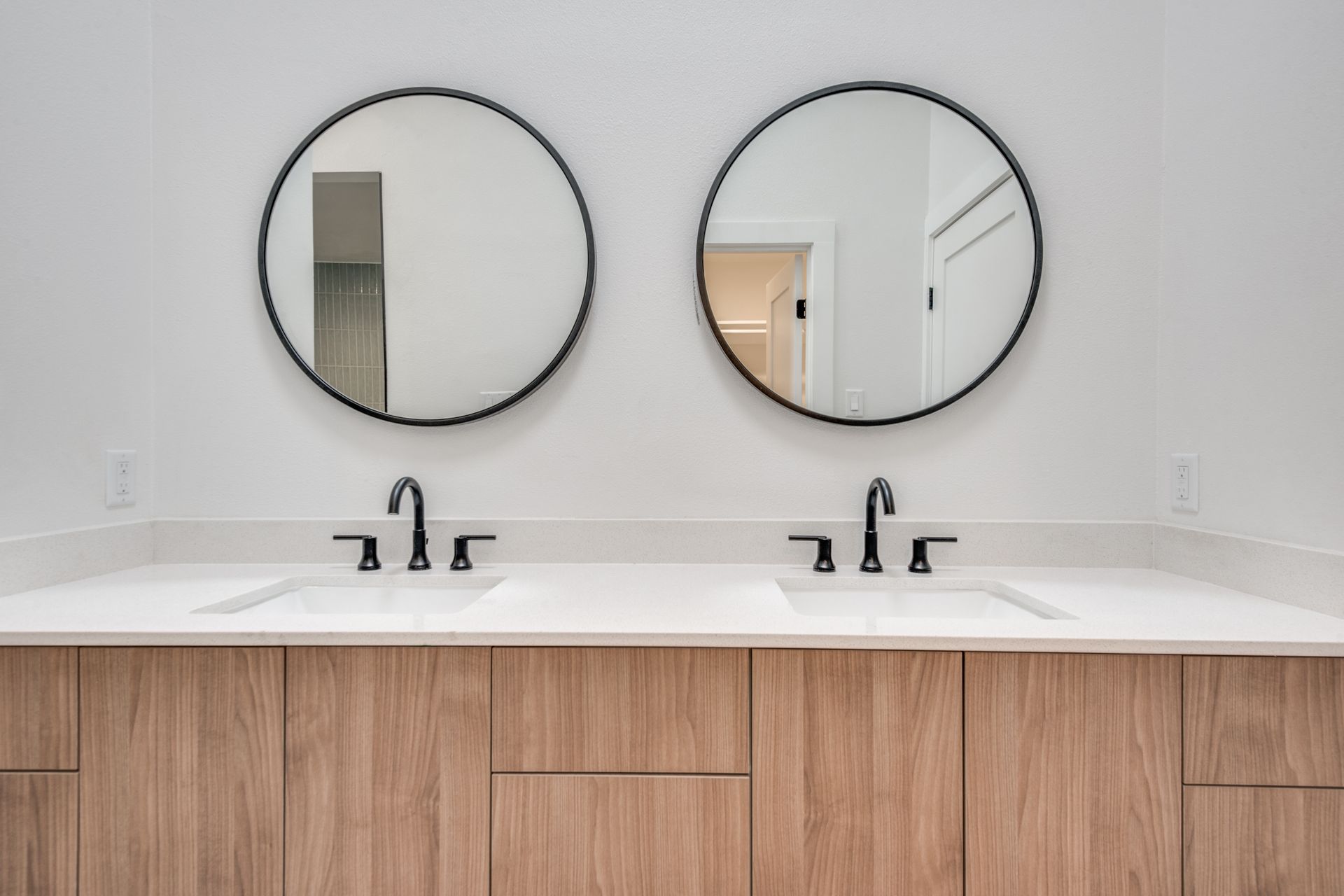 A bathroom with two sinks and two mirrors.