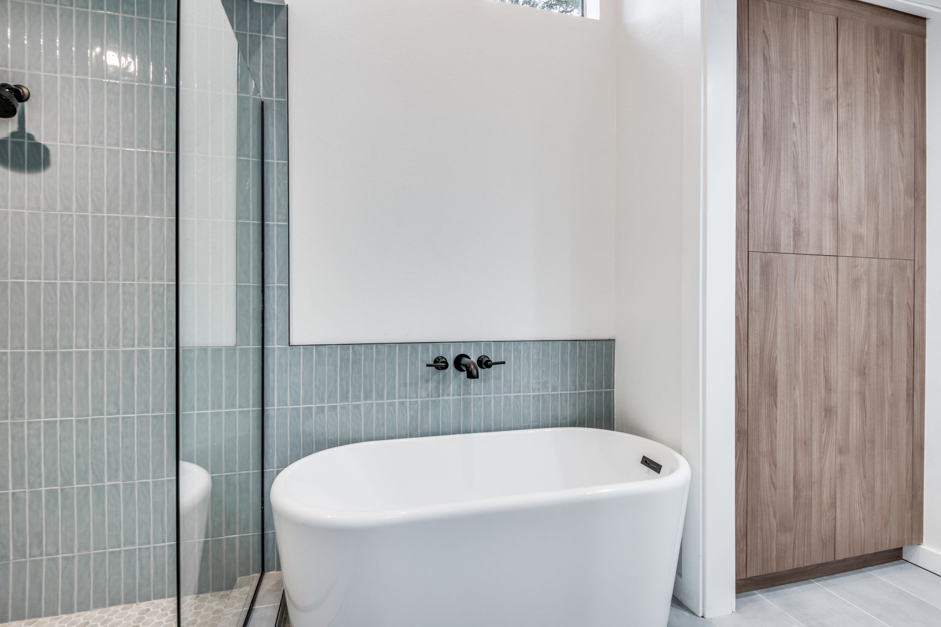 A bathroom with a bathtub , toilet , shower and mirror.