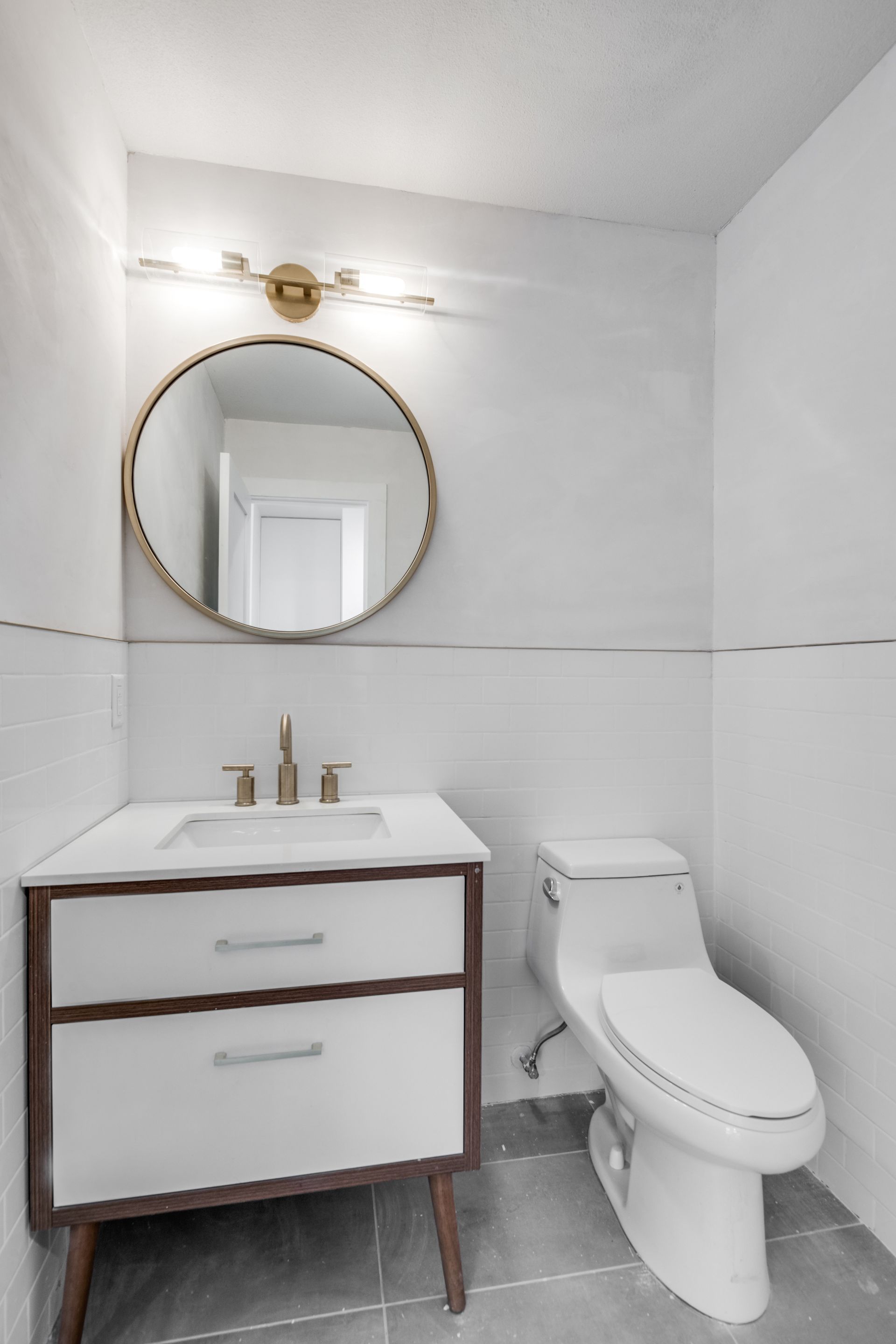 A bathroom with a toilet , sink and mirror
