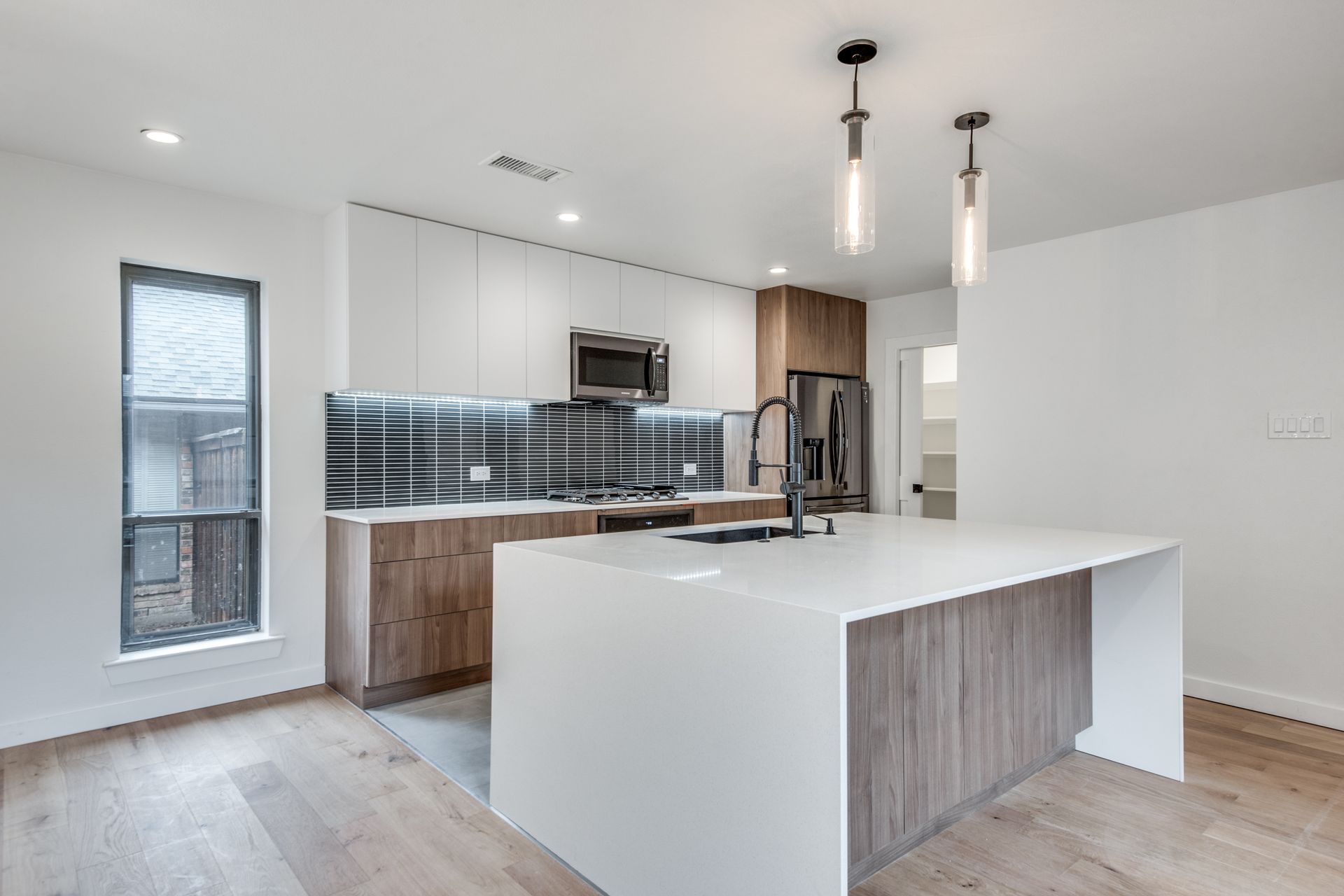 An empty kitchen with a large island in the middle