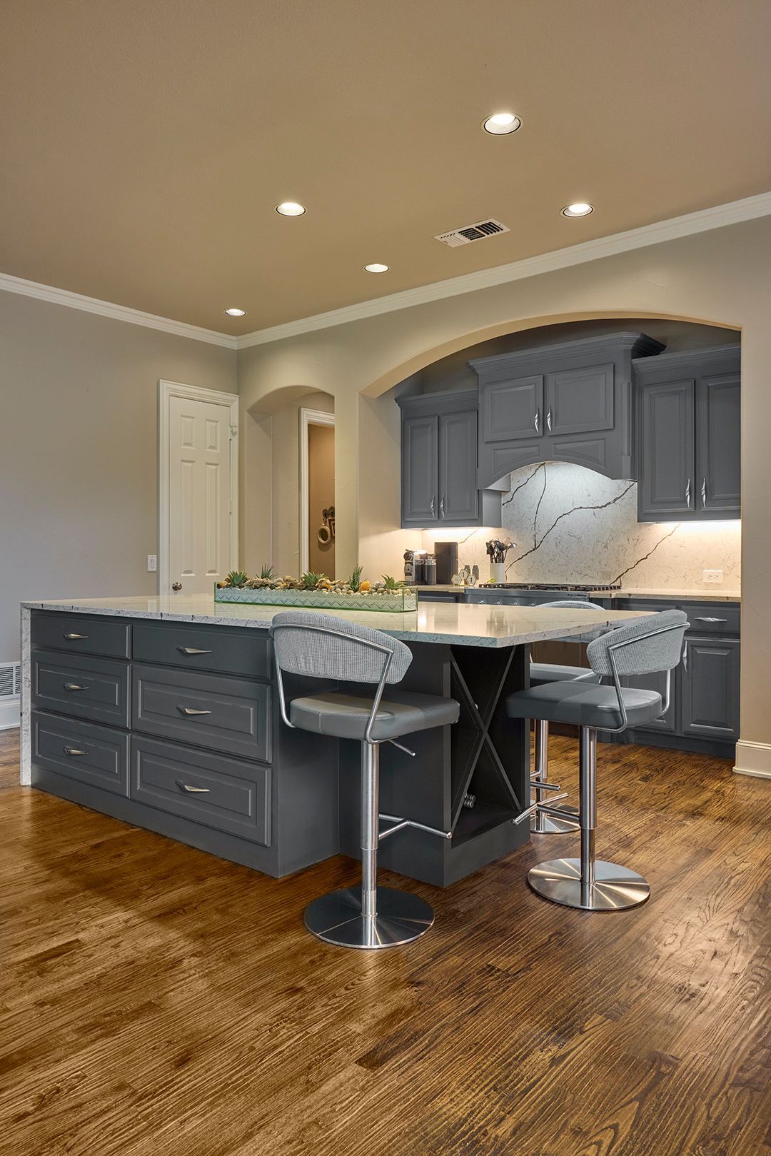 A kitchen with a large island and stools.