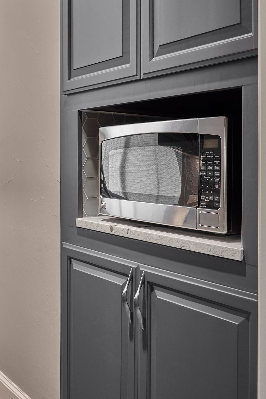 A microwave oven is built into a cabinet in a kitchen.