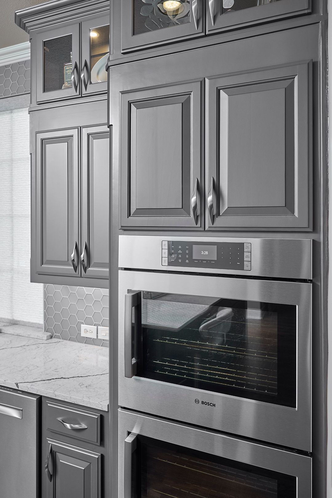 A kitchen with stainless steel appliances and gray cabinets