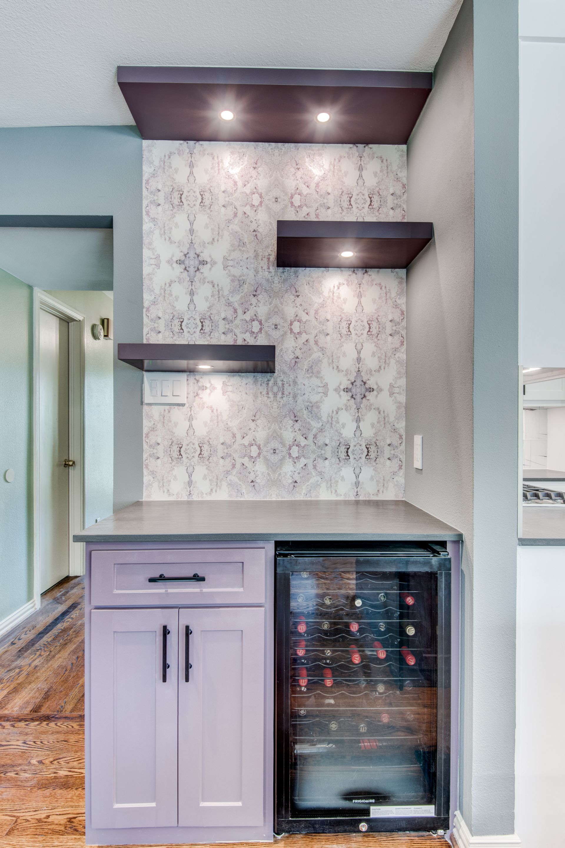 A kitchen with purple cabinets and a wine cooler
