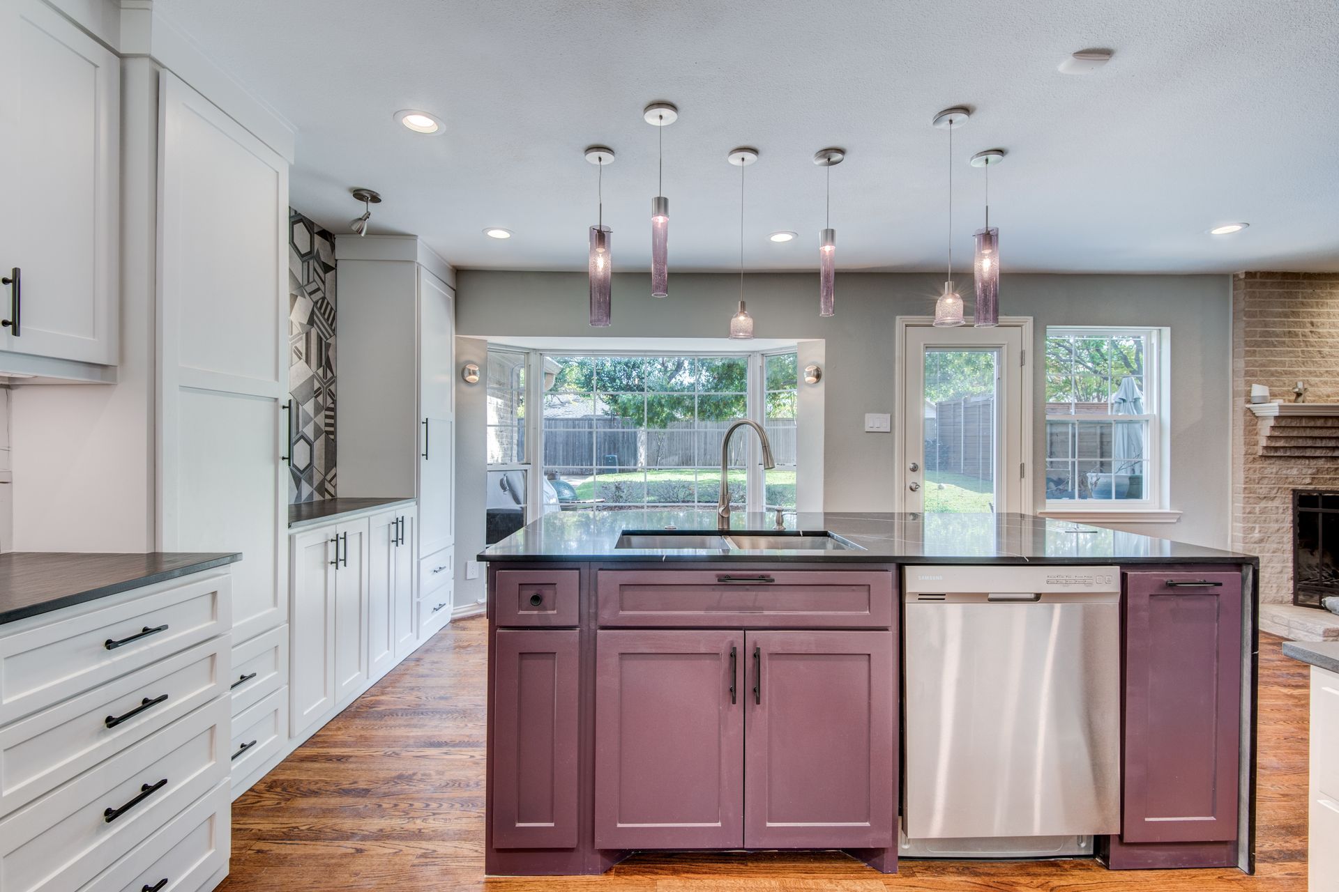 A kitchen with purple cabinets and stainless steel appliances.