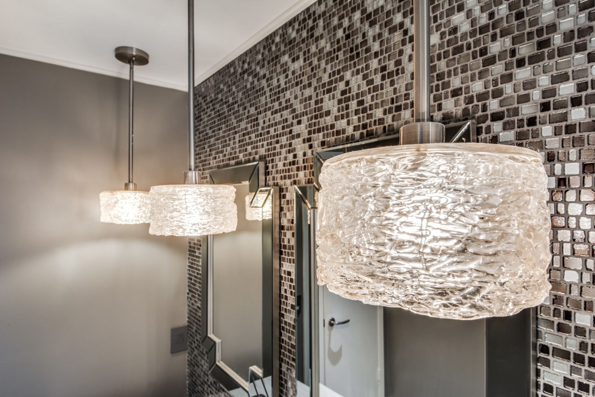 Three pendant lights are hanging from the ceiling in a bathroom.