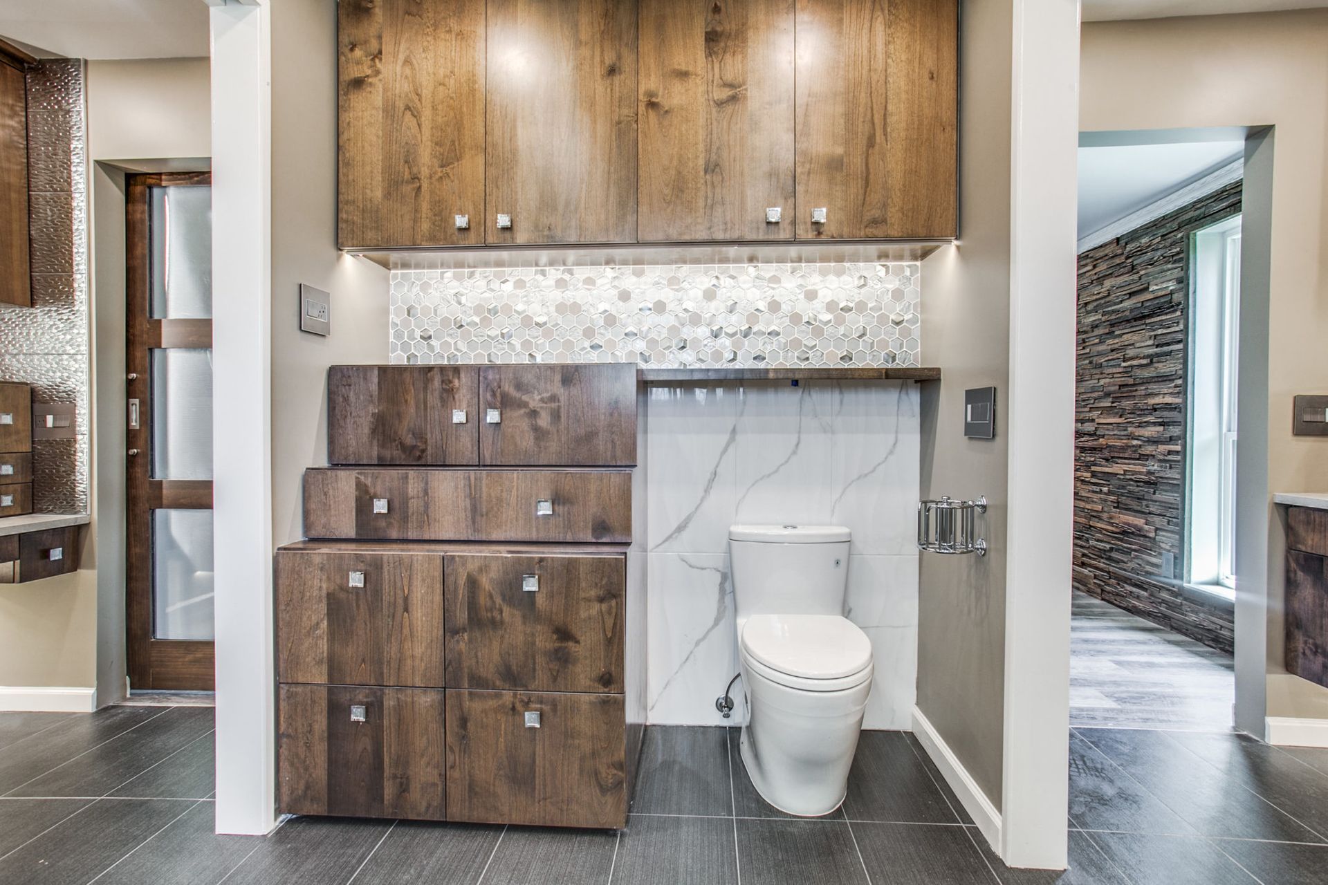 A bathroom with a toilet and wooden cabinets.