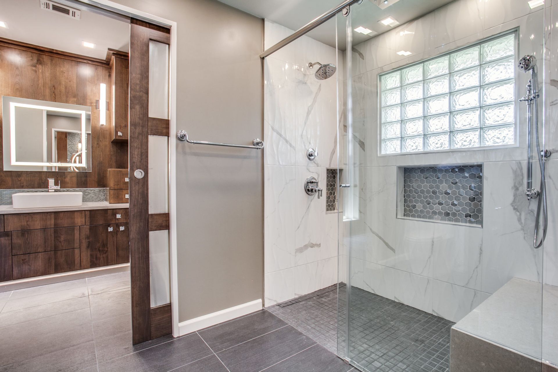 A bathroom with a walk in shower and a sink.