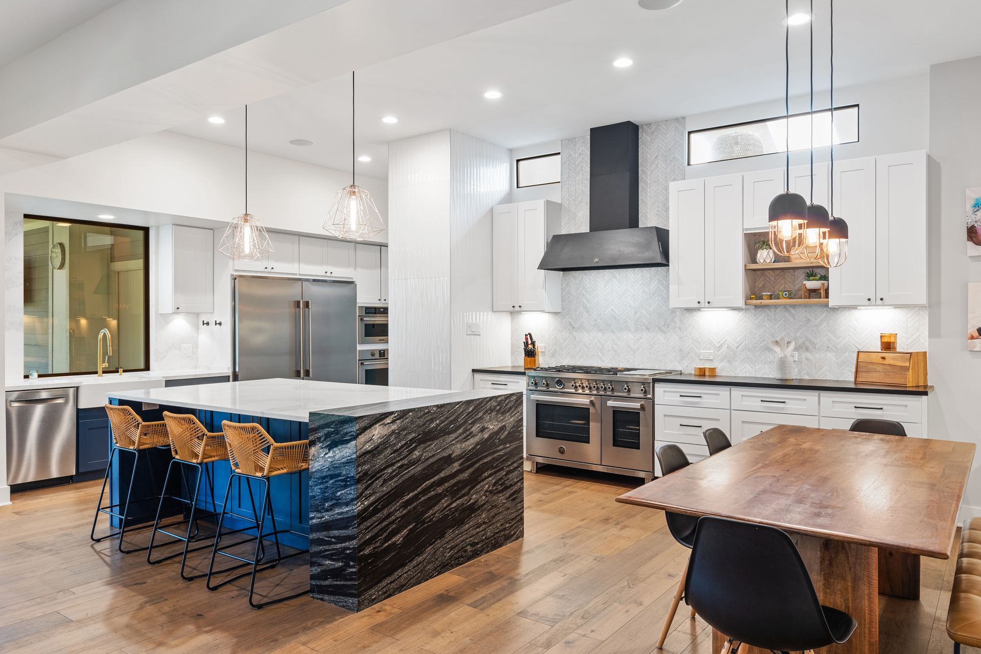 A kitchen with a large island and a dining table.