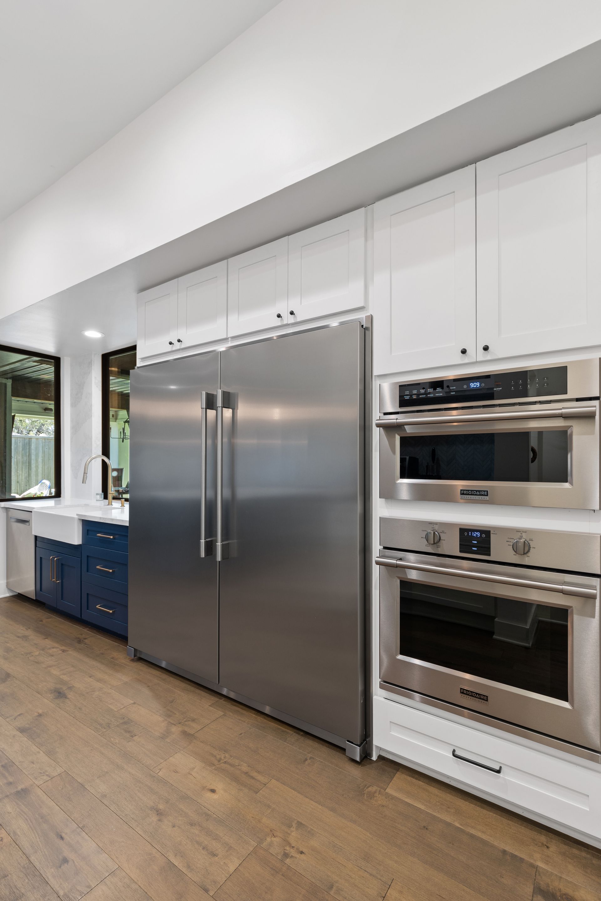 A kitchen with stainless steel appliances and white cabinets.