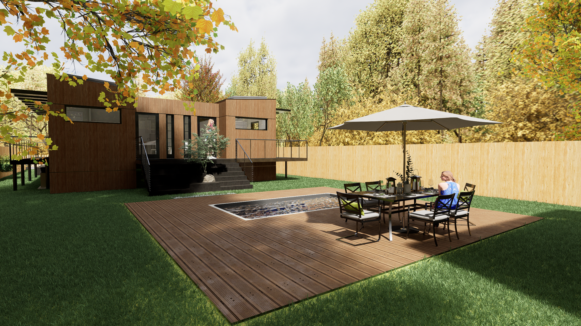 A man is sitting at a table with an umbrella in front of a house.