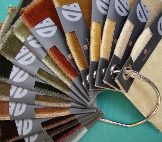 Three bottles of cosmetics are sitting on a table next to a pink box.