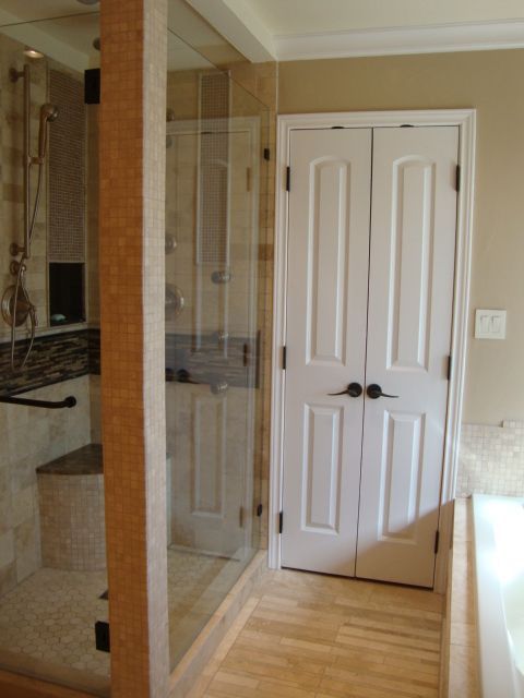 A bathroom with a walk in shower and a closet
