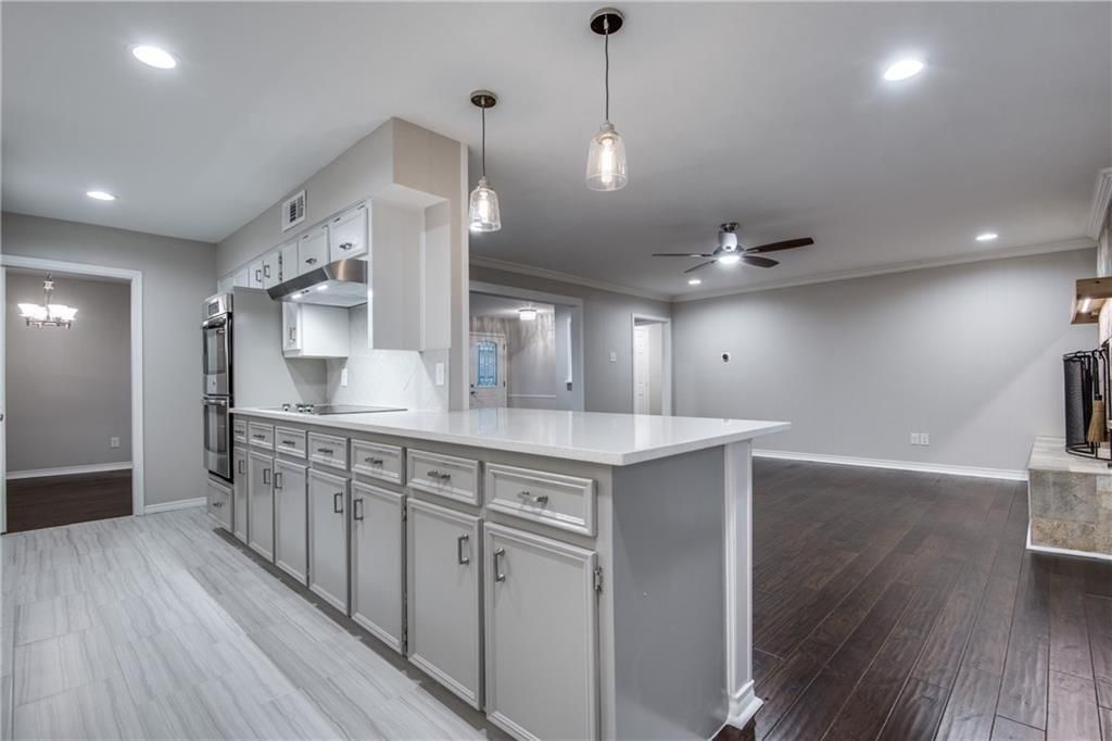 A kitchen with white cabinets and a large island in the middle of the room.