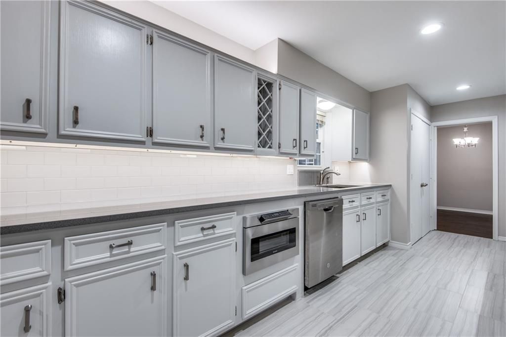 A kitchen with white cabinets and stainless steel appliances.