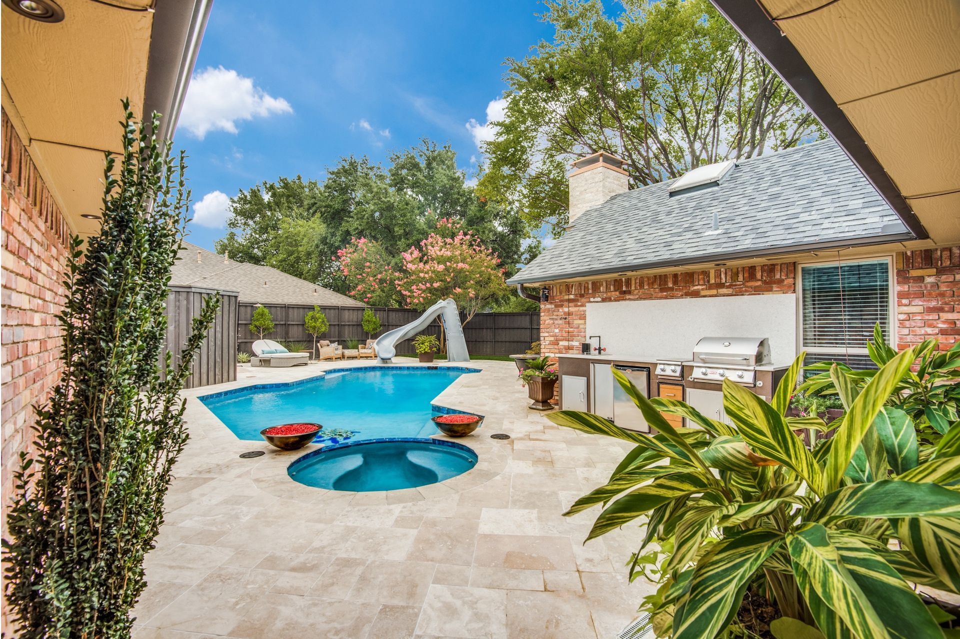 There is a large swimming pool in the backyard of a house.