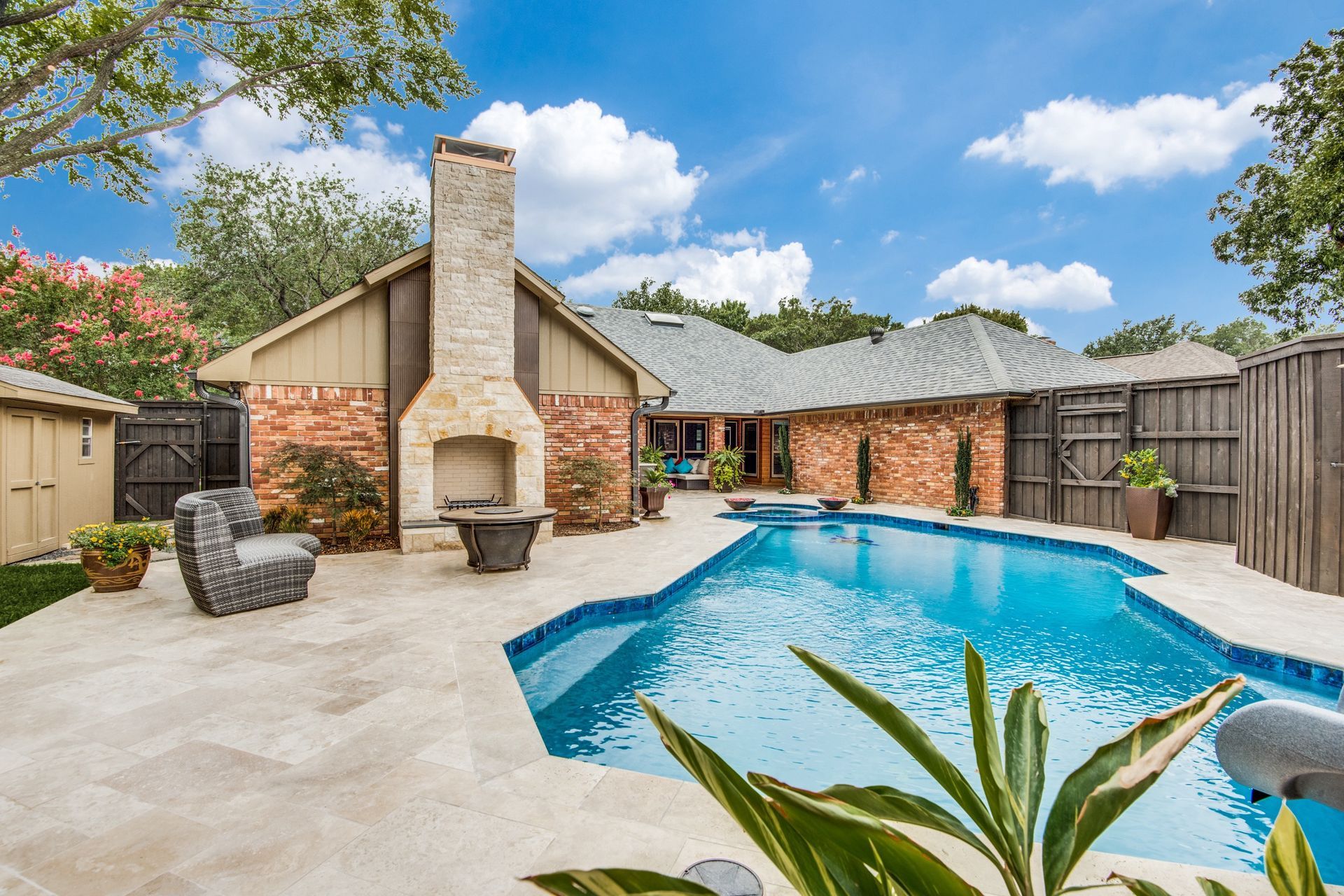 A large swimming pool is in the backyard of a house.