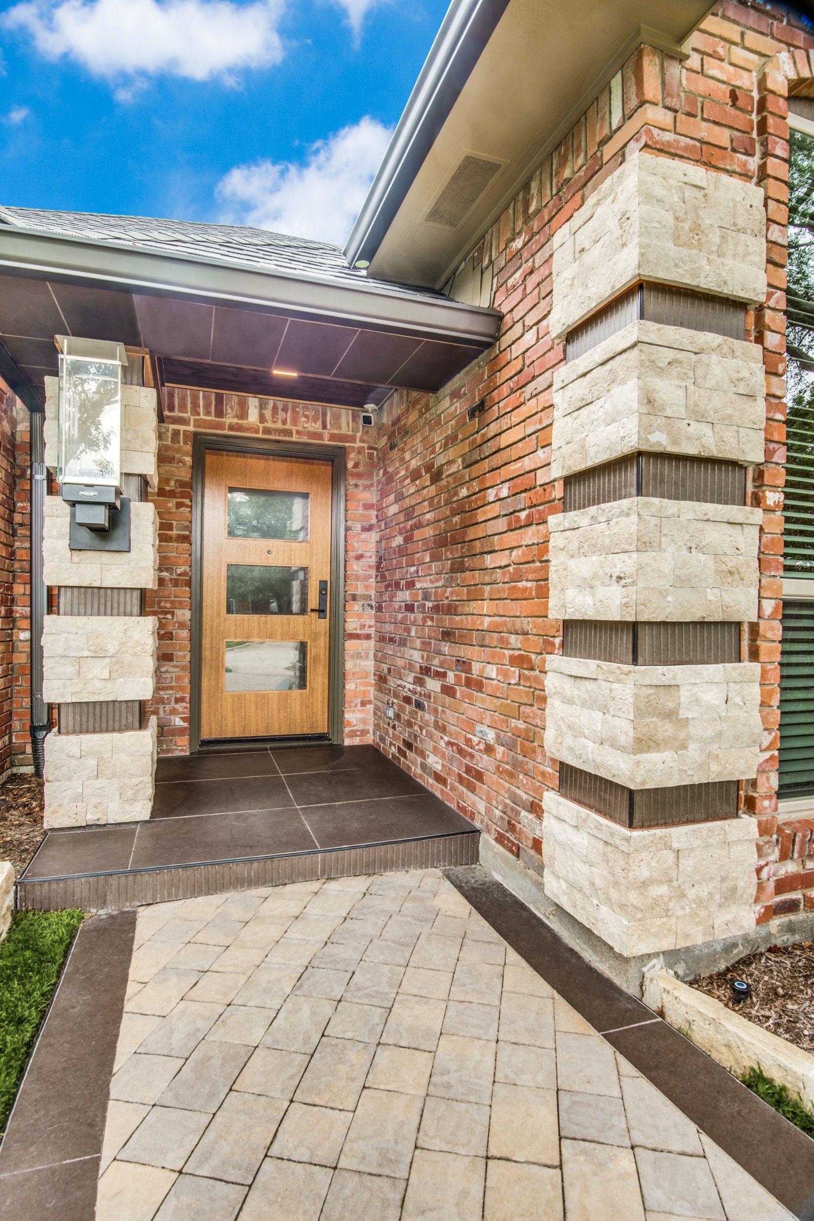 A brick house with a wooden door and a brick walkway