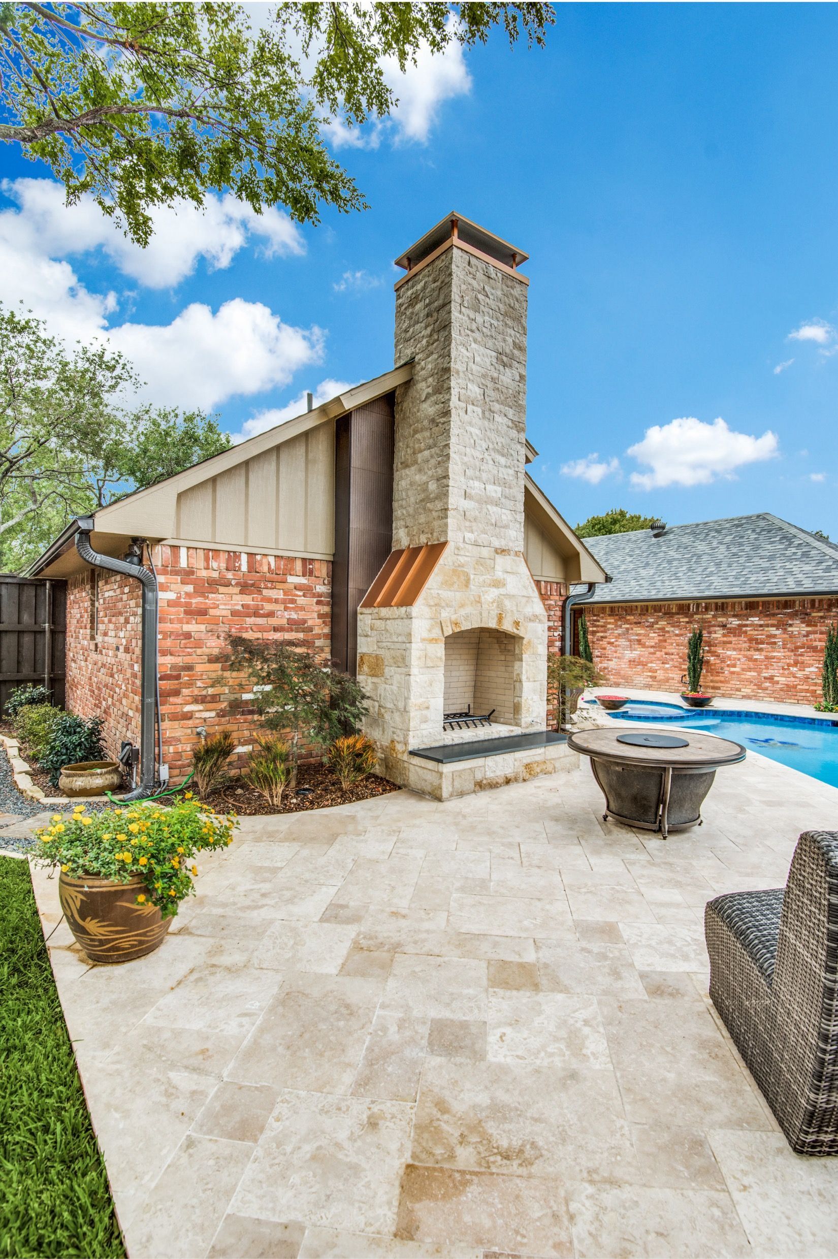 A house with a fireplace and a swimming pool in the backyard.
