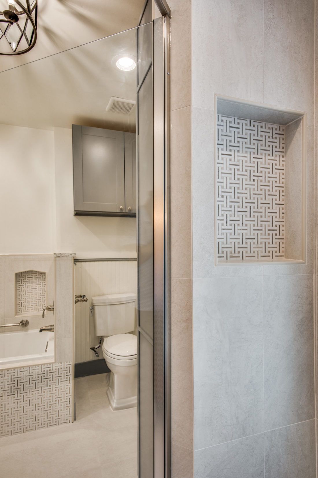A bathroom with a toilet , tub , shower and mirror.