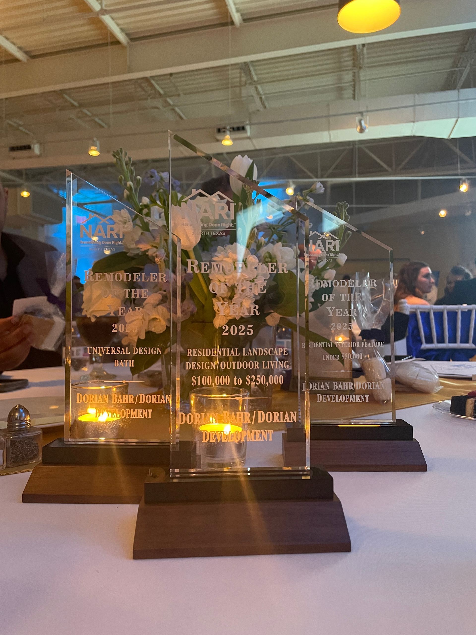 Three trophies are sitting on a table in a room.