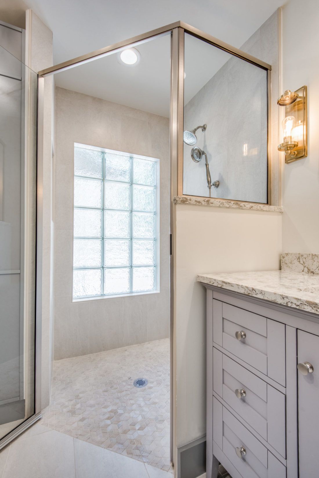 A bathroom with a walk in shower and a sink.