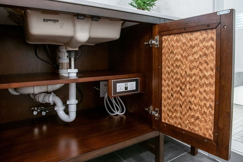 A bathroom vanity with the door open and a sink underneath it.