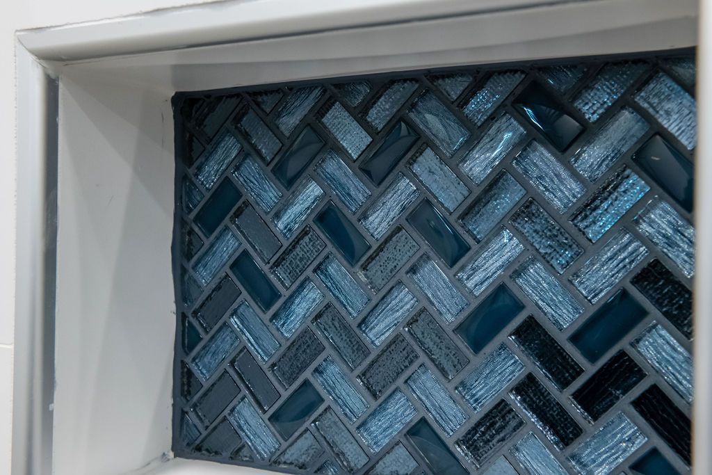 A blue and black tile wall with a herringbone pattern