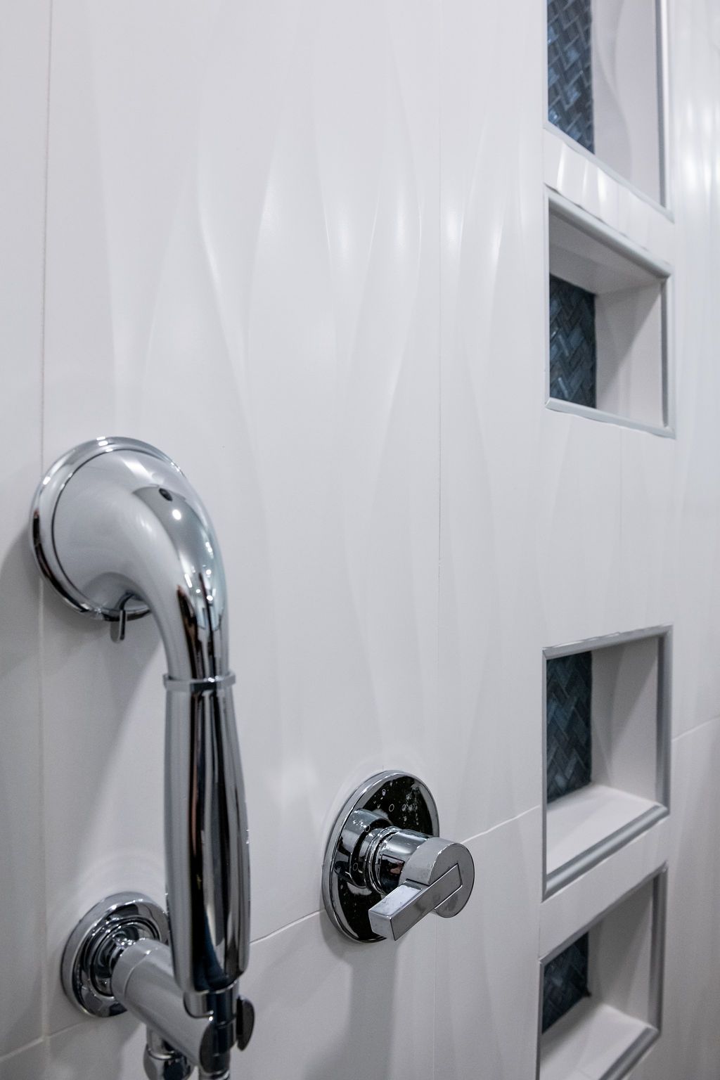 A close up of a shower head in a bathroom.