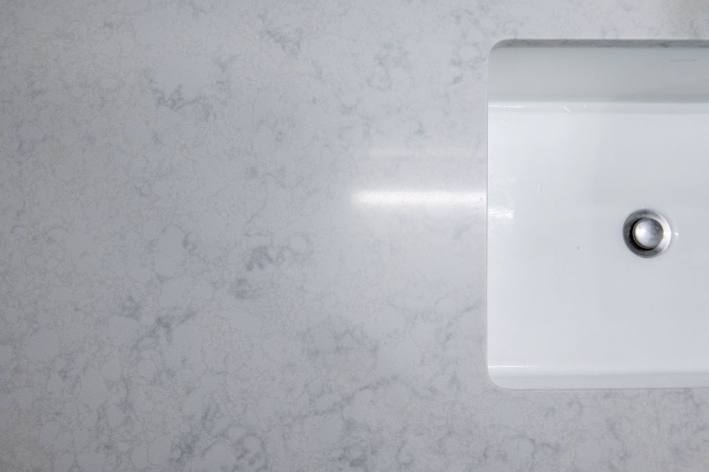 A white sink is sitting on top of a white counter top.