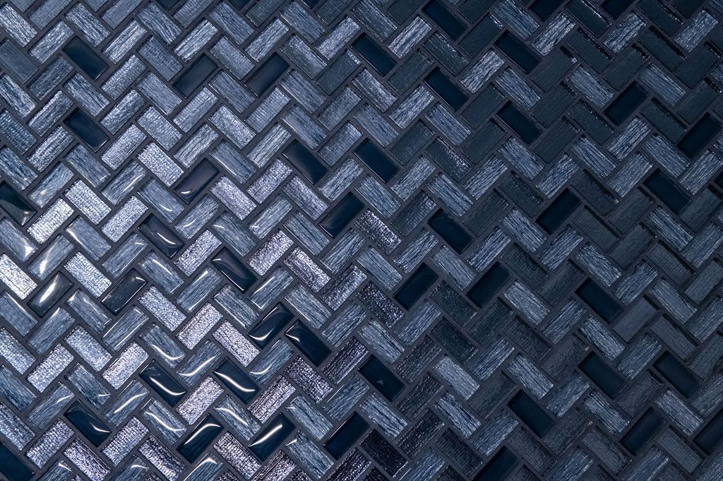 A close up of a blue and silver mosaic tile wall.