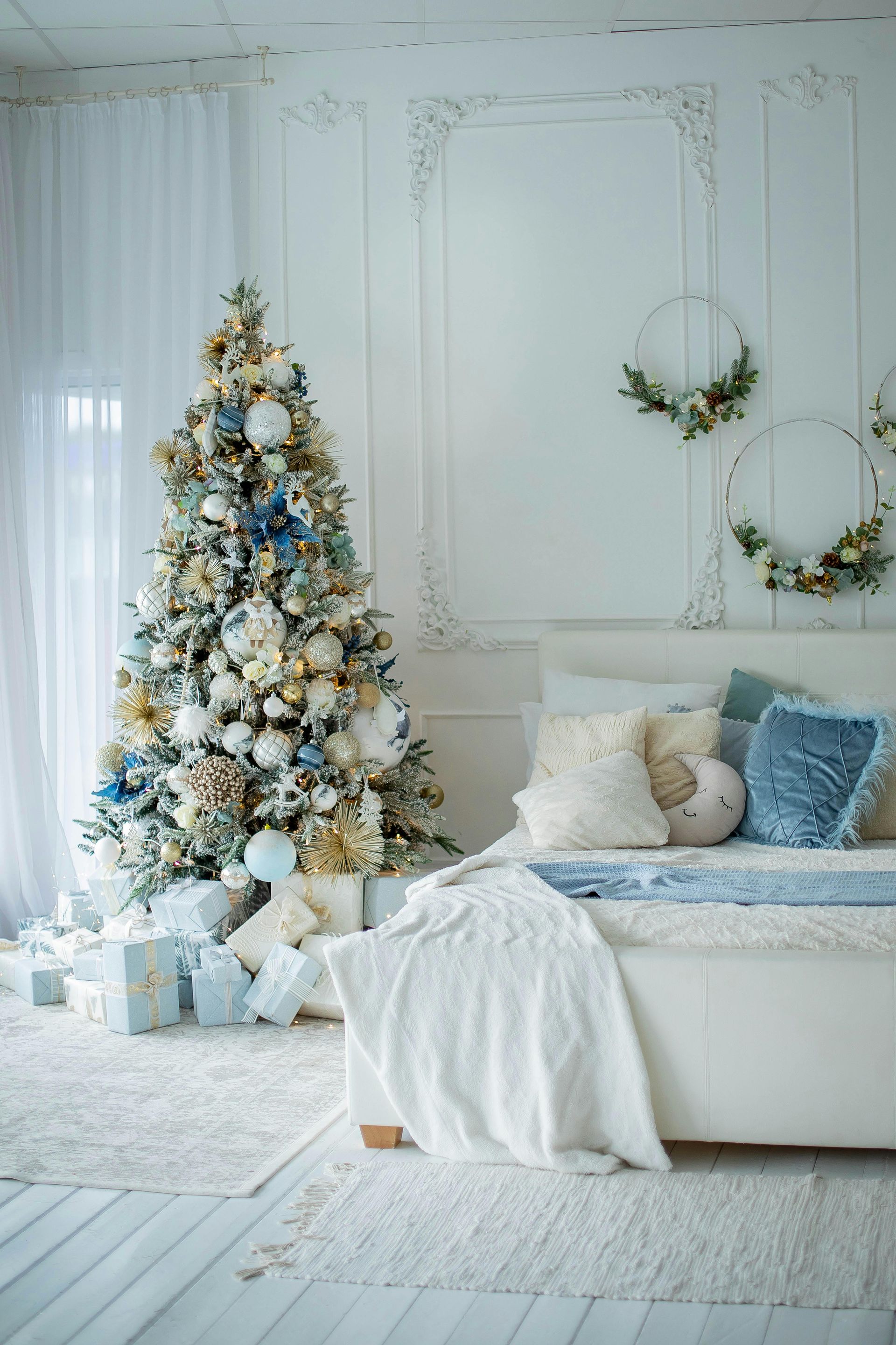 A bedroom decorated for christmas with a christmas tree and a bed.