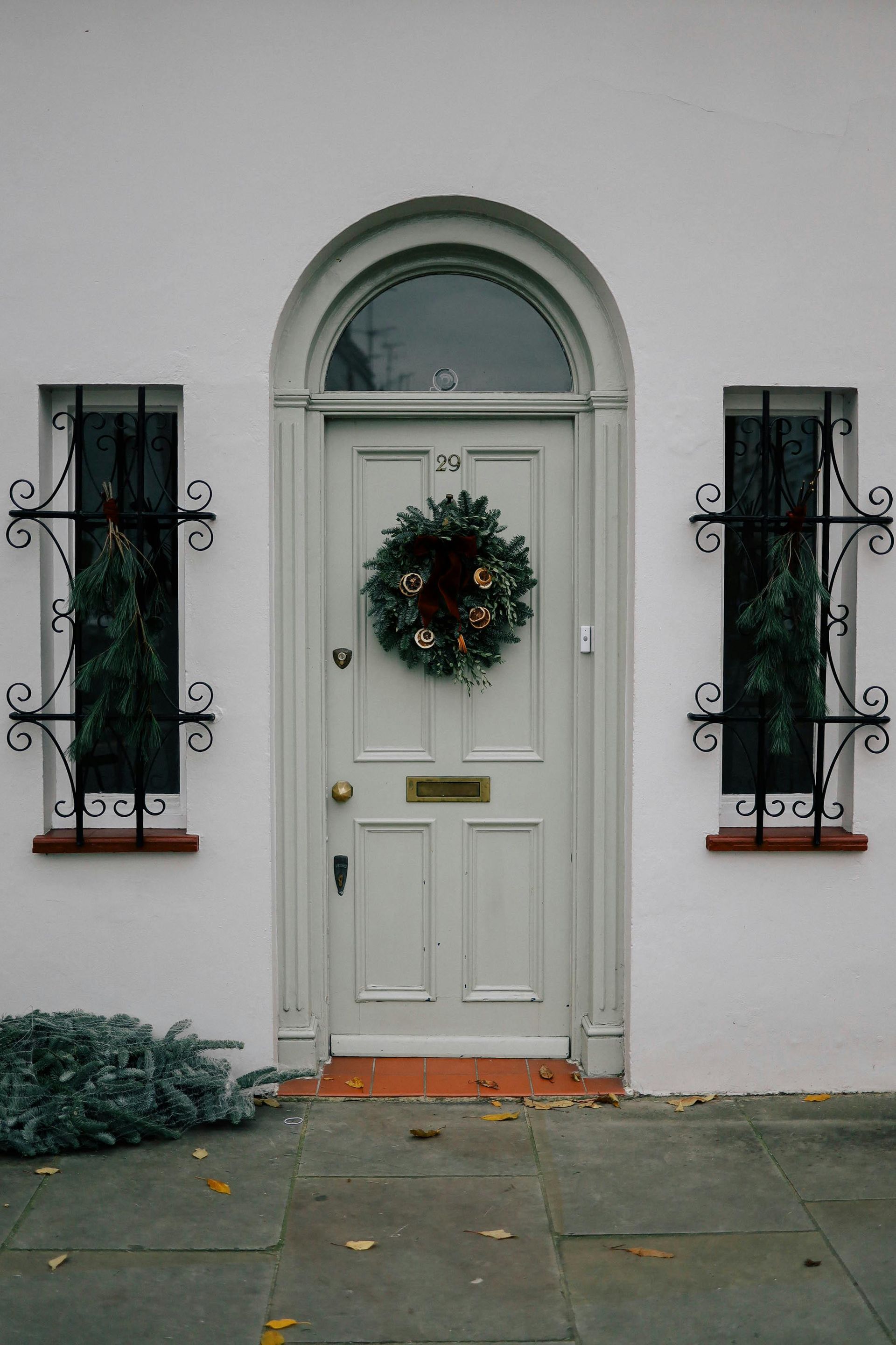 A white door with a christmas wreath hanging on it.