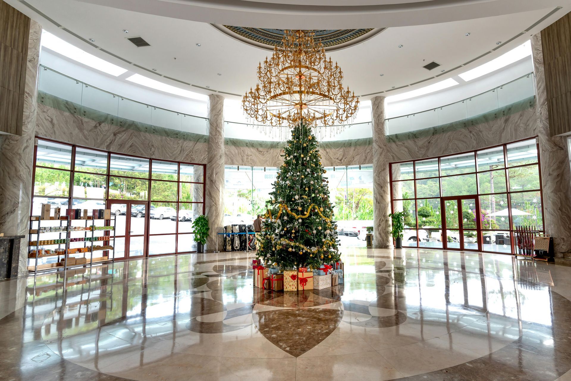 A large lobby with a christmas tree and a chandelier.