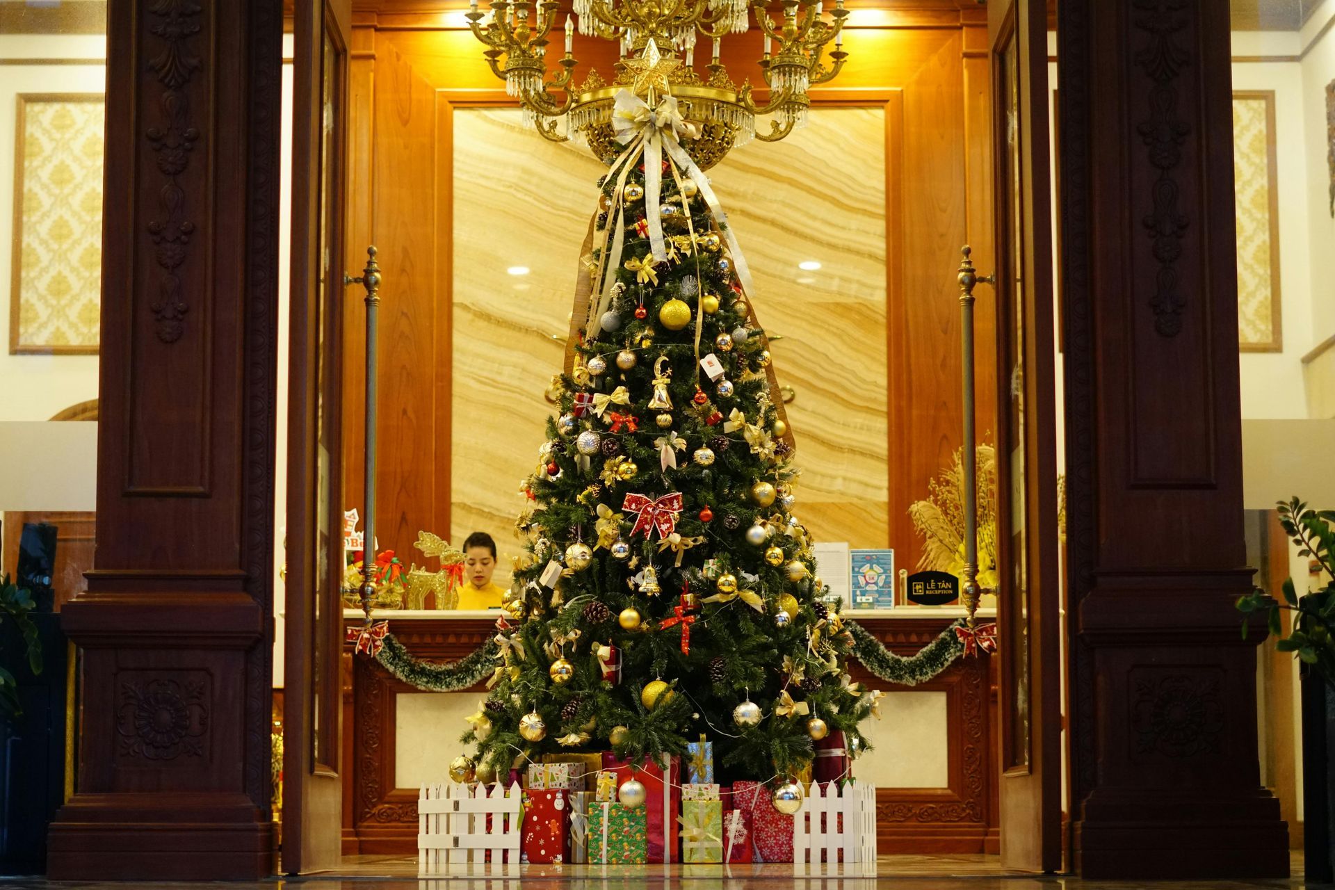 A large christmas tree is sitting in the middle of a lobby.