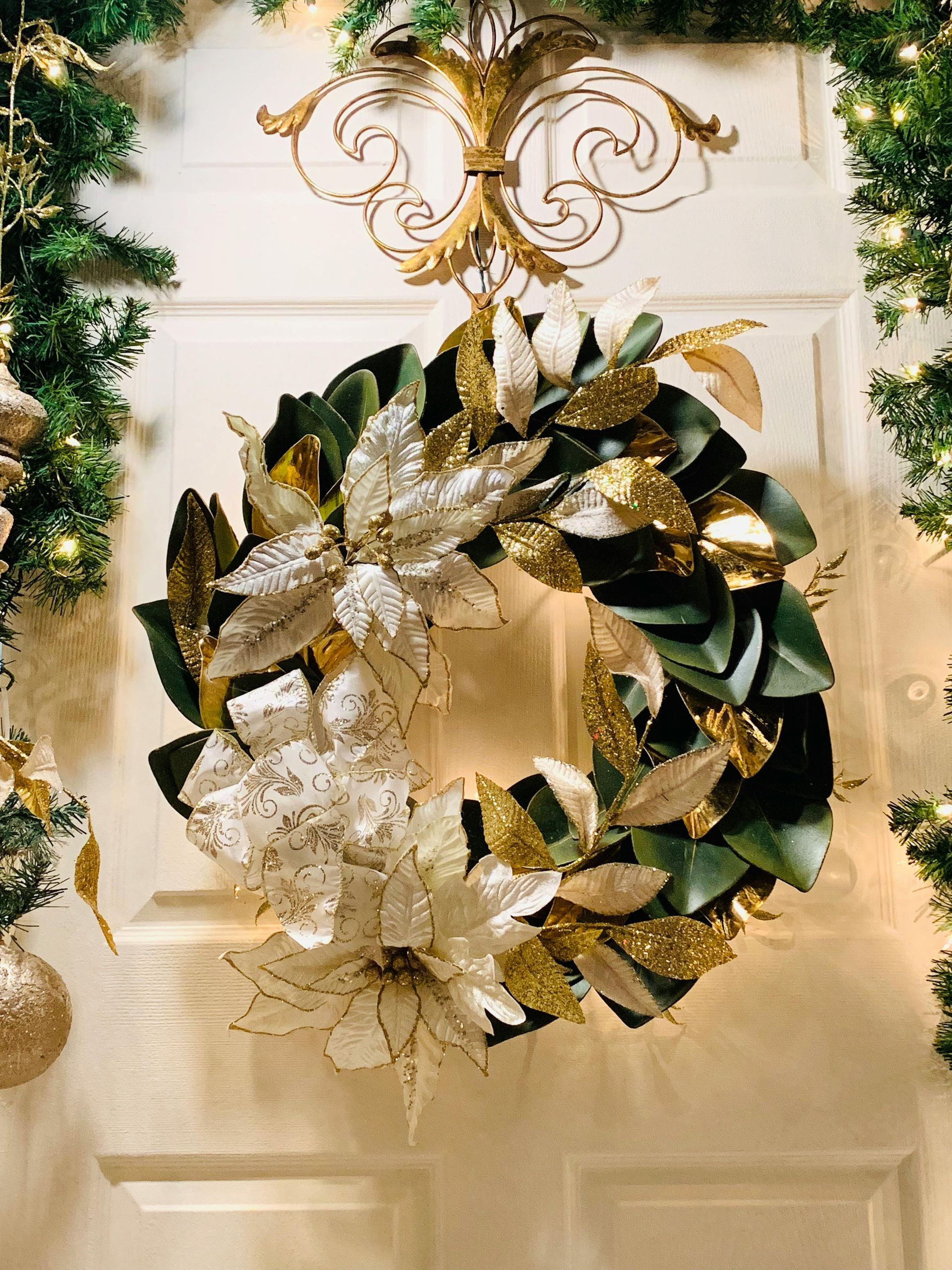 A christmas wreath is hanging on a door next to a christmas tree.