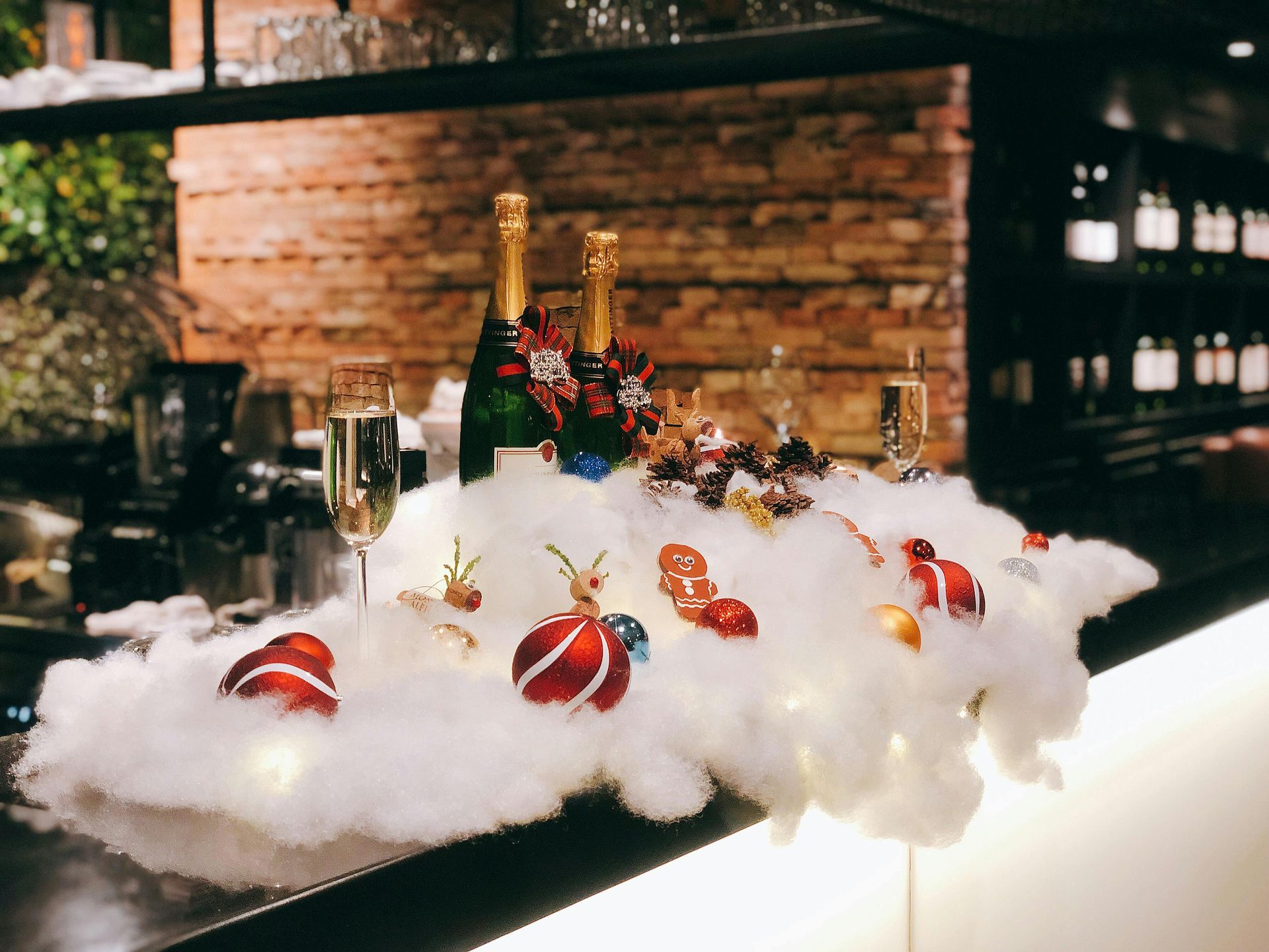 A bar with bottles of champagne and christmas decorations on it.