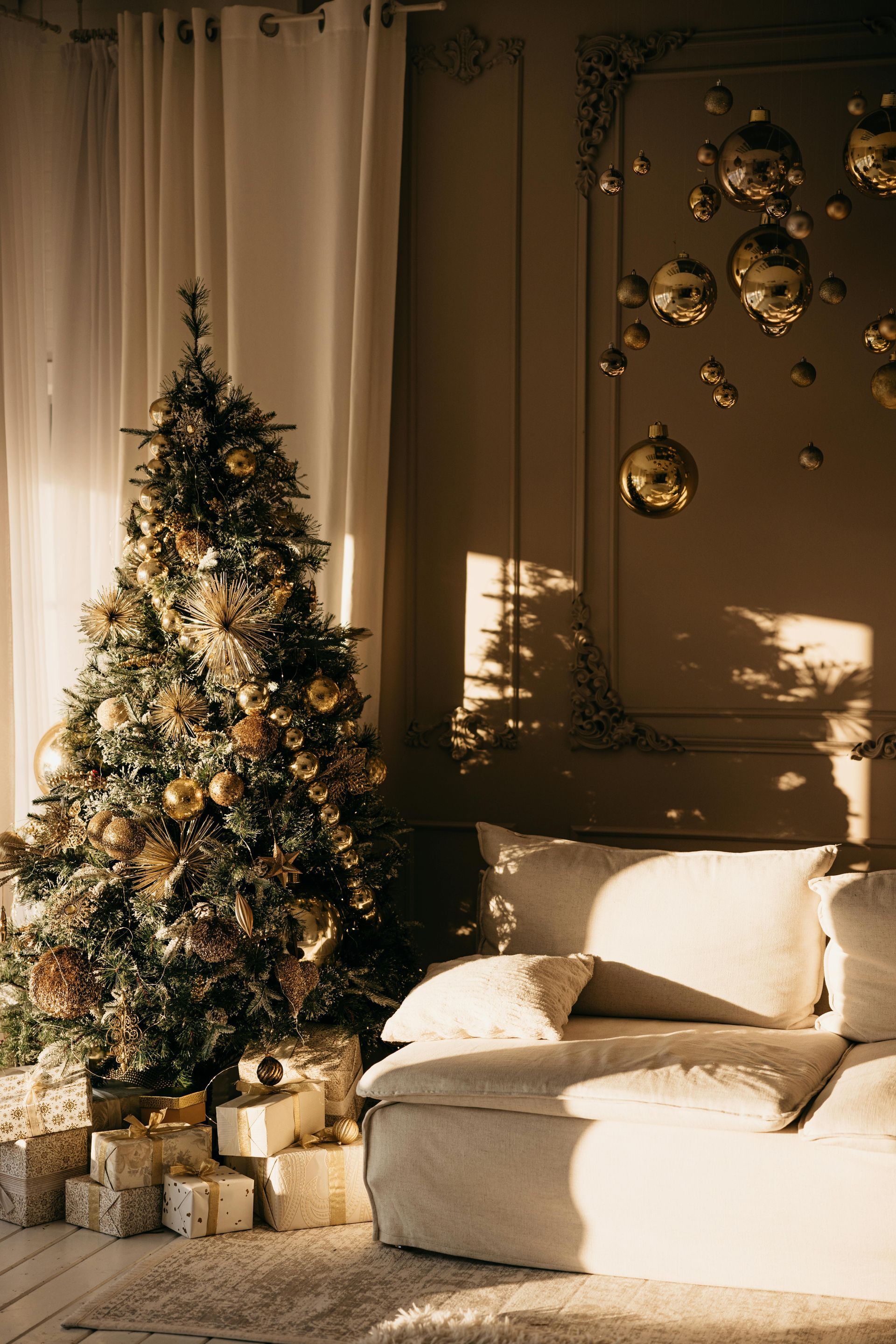 A living room with a christmas tree and a couch.
