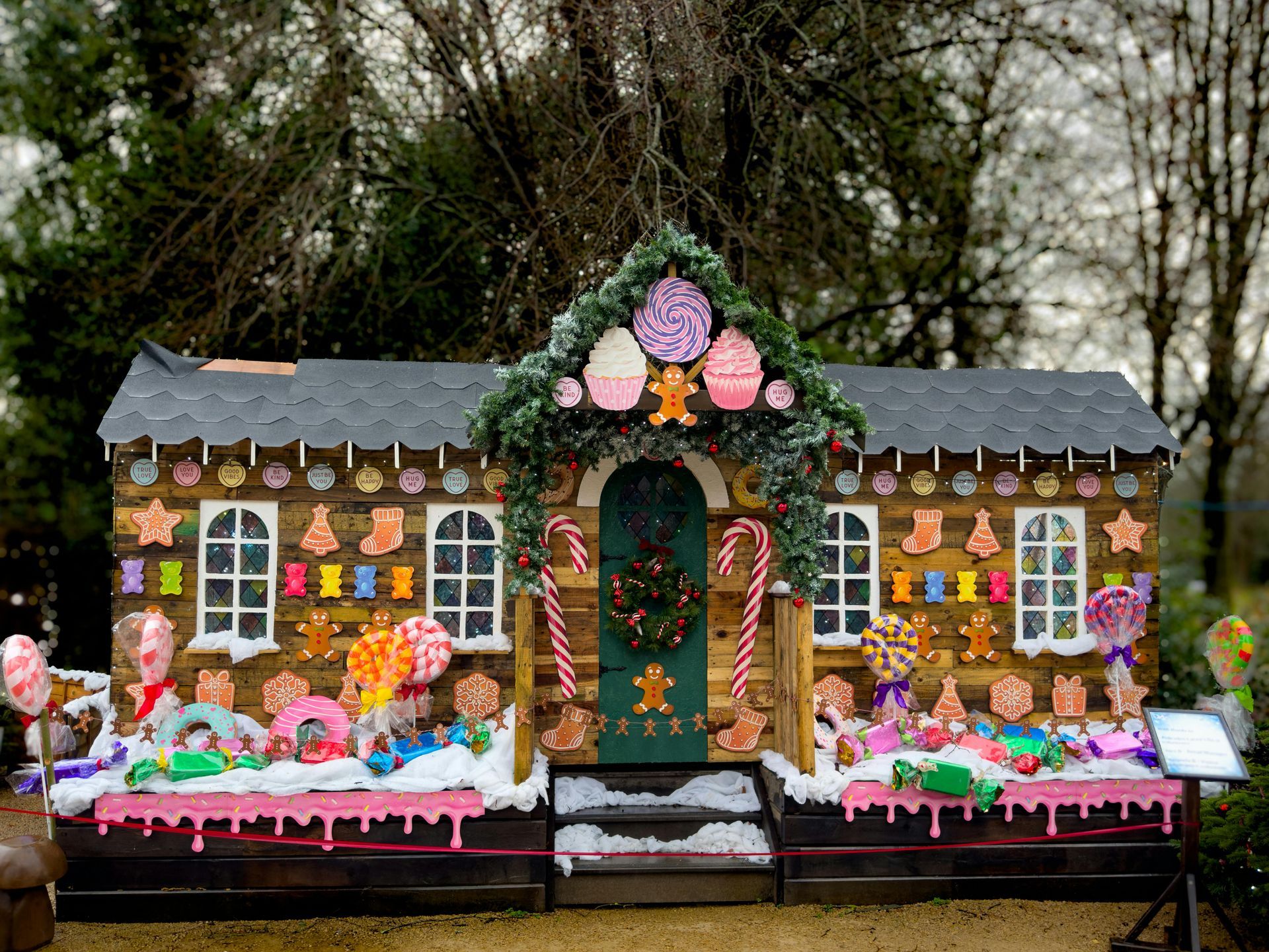 A large gingerbread house decorated with candy and lollipops.