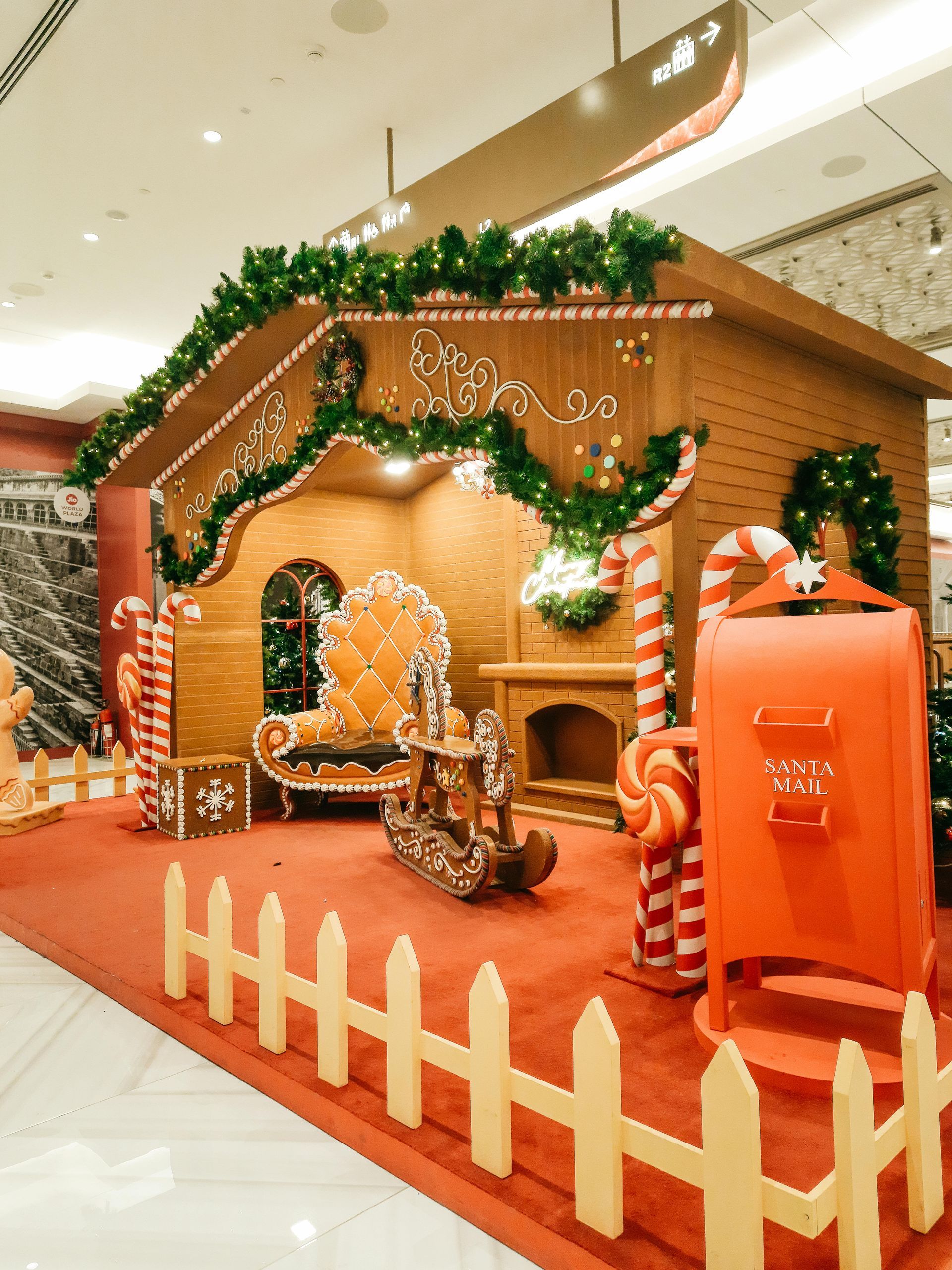 A gingerbread house is decorated with candy canes and a mailbox.
