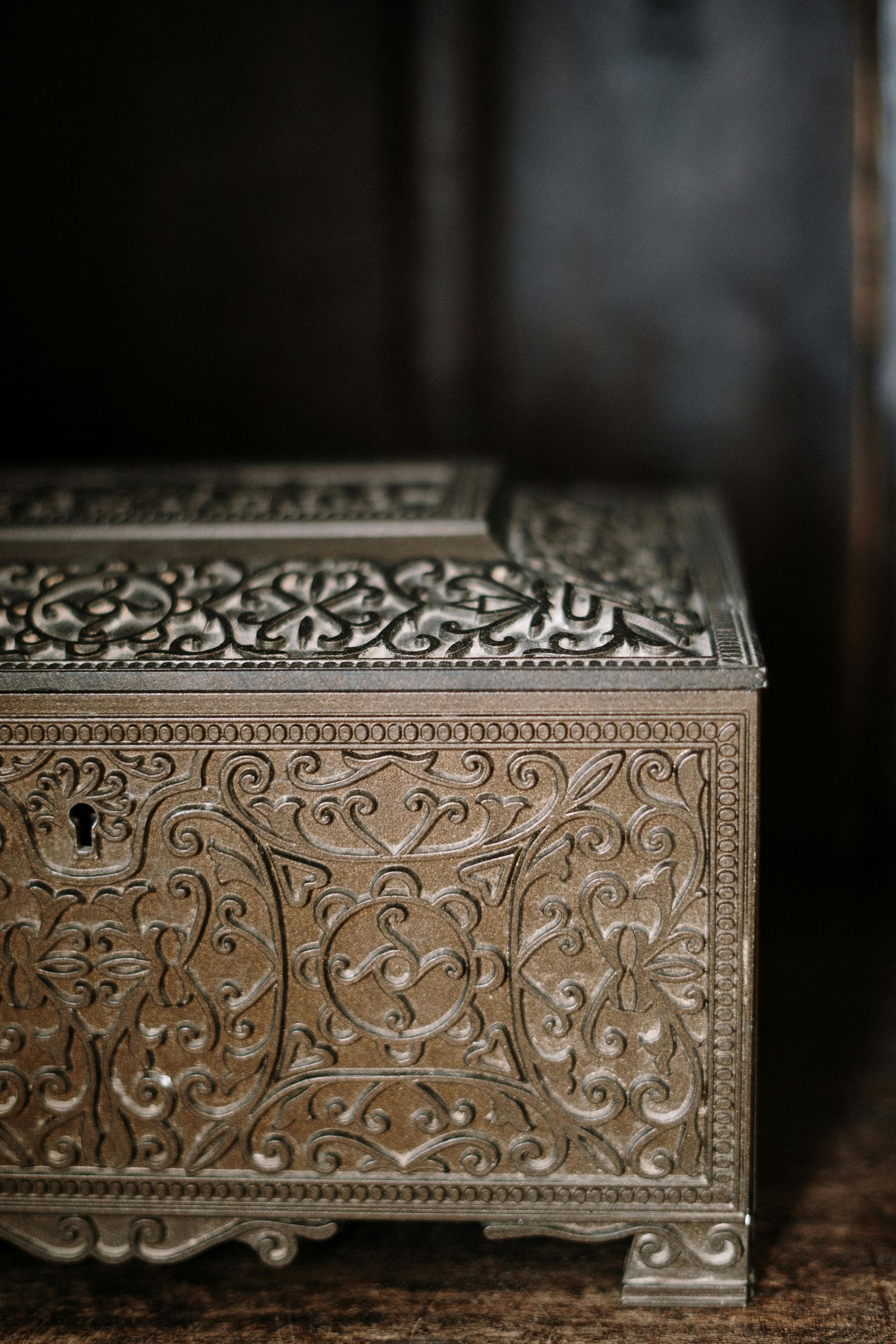 A close up of a silver treasure chest on a wooden table.