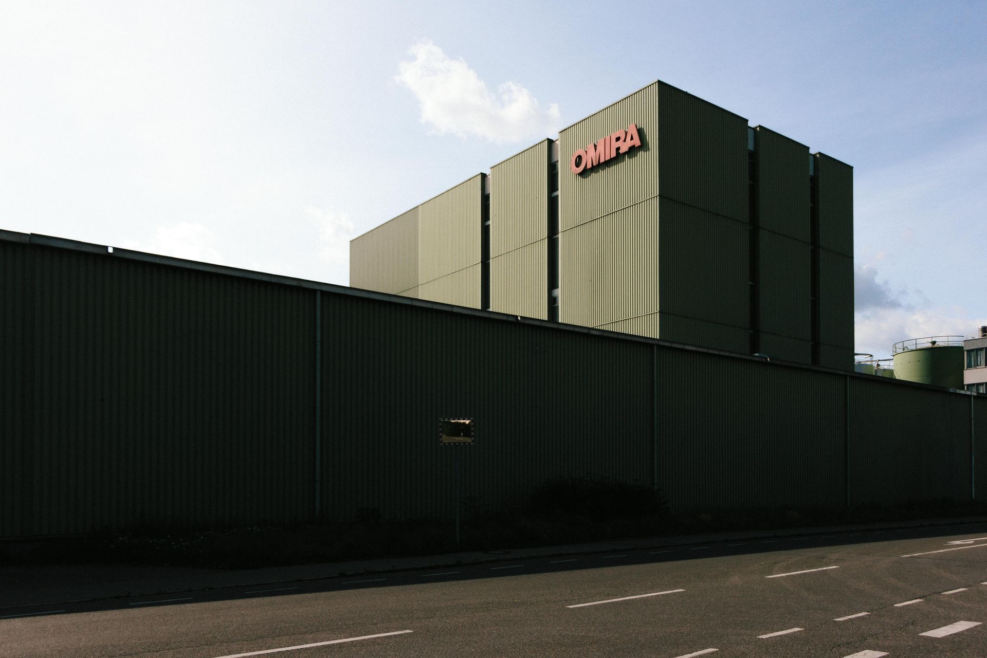 A large green building with the word omega on it