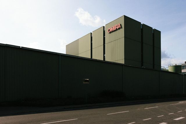 A large green building with the word omega on it