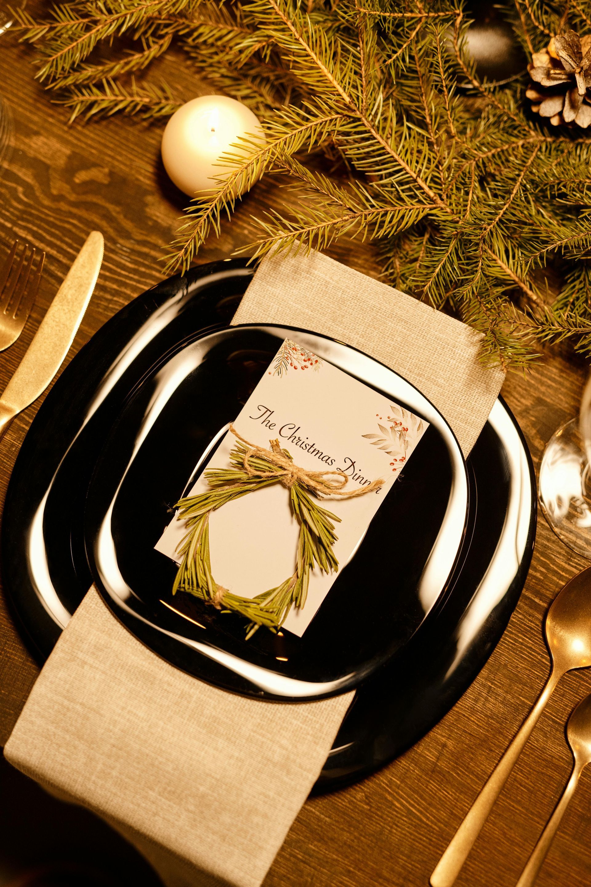 A place setting for a christmas dinner with a place card on a plate.