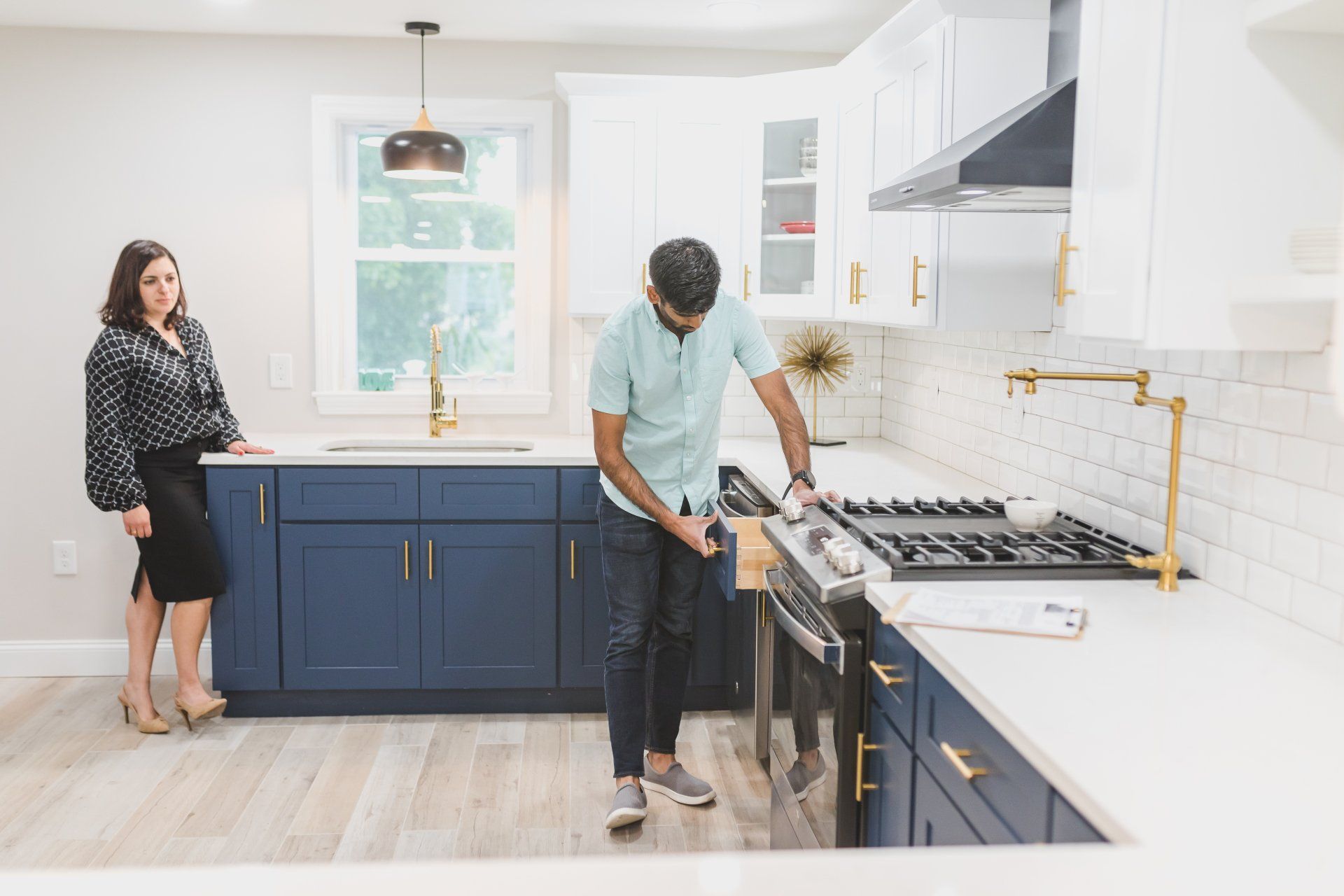 A man and a woman are standing in a kitchen.