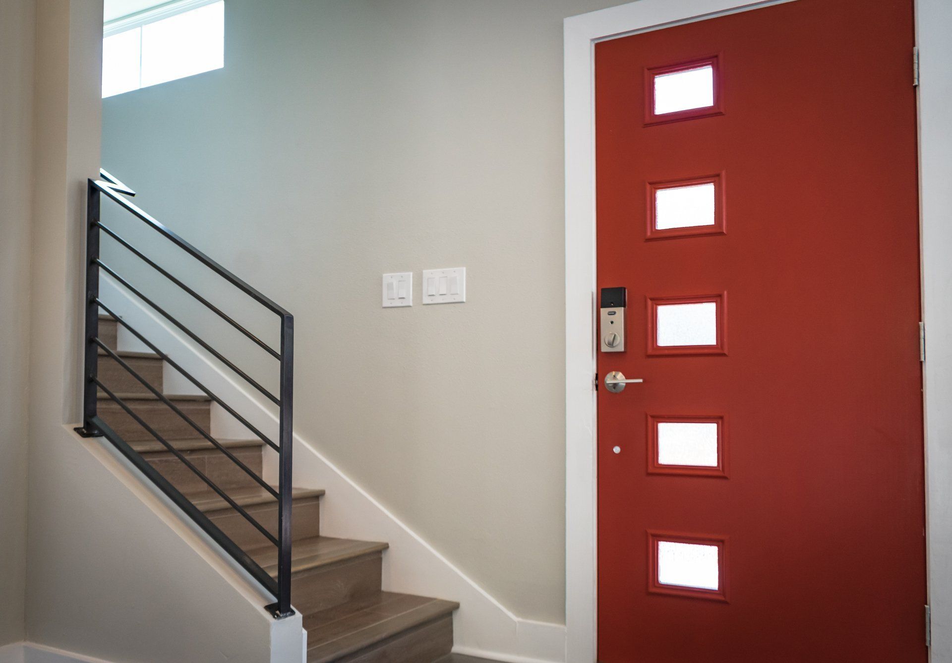 Stairs leading up to a red door with square windows